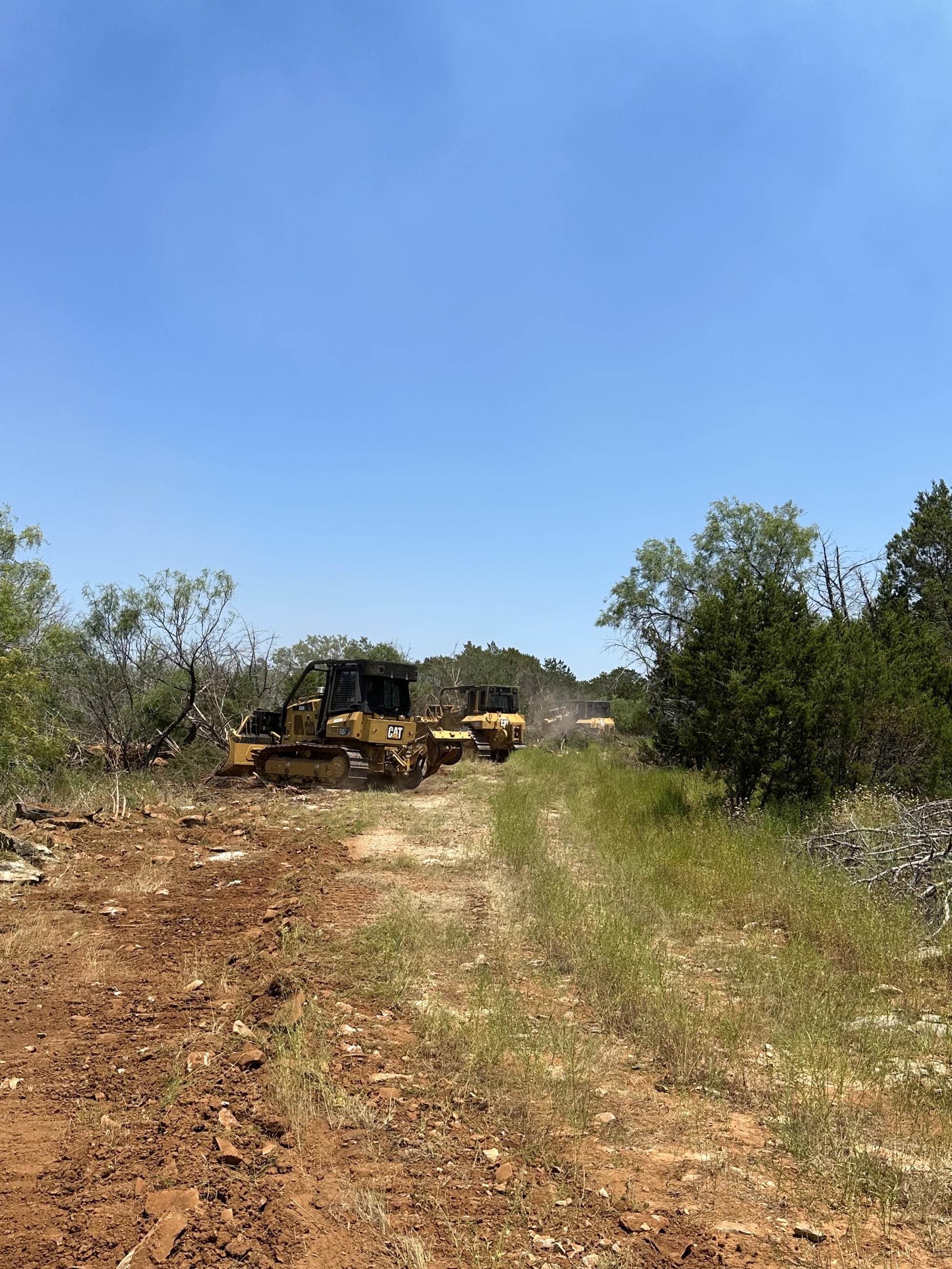 3 Bulldozers along the left half of the picture work to push brush away from a previously constructed dozer line, working to expand the containment line.