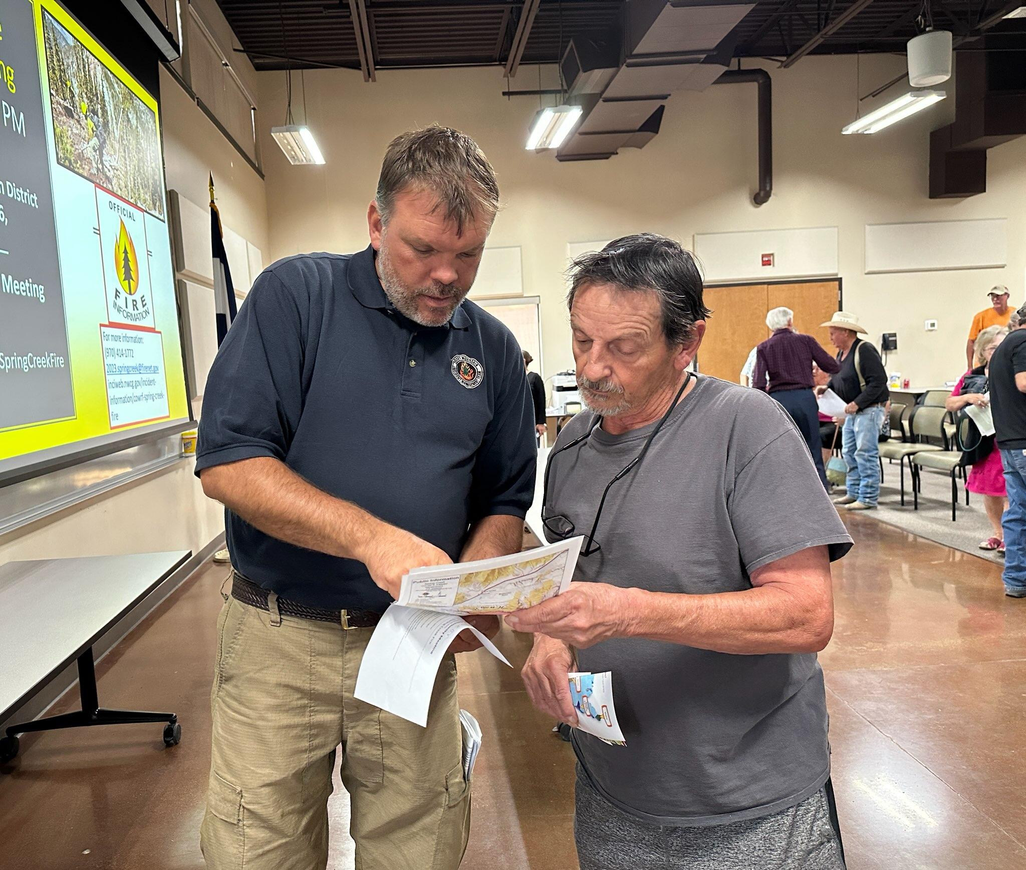 a incident management team member shares info with a resident at community meeting