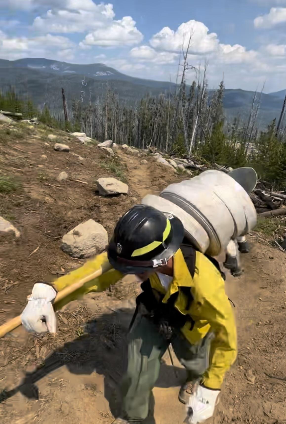 Firefighter installing a hose lay on the Bowles Creek Fire, on July 29, 2023