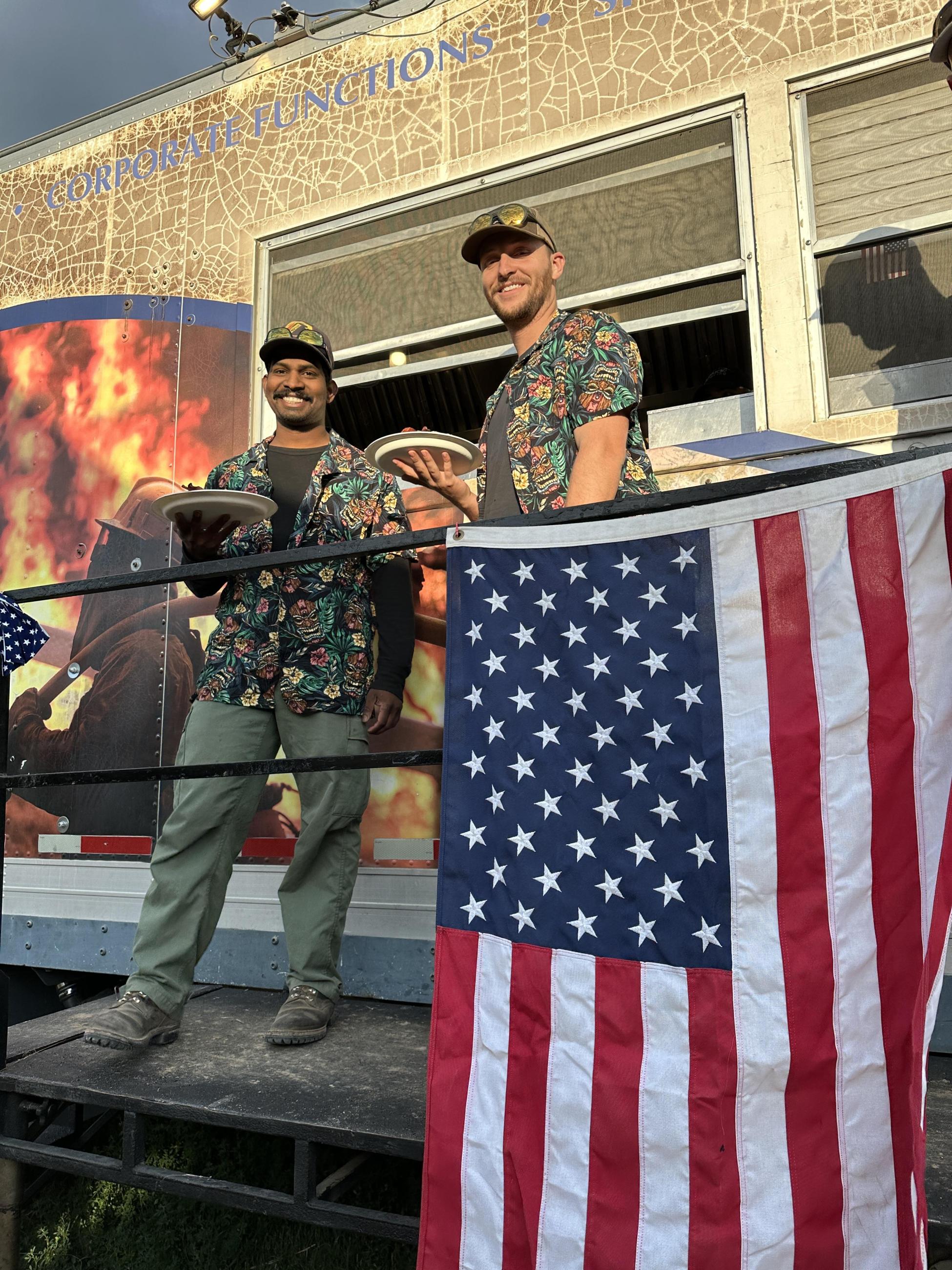 Two members of a fire crew wear festive shirts at breakfast on the fourth of july