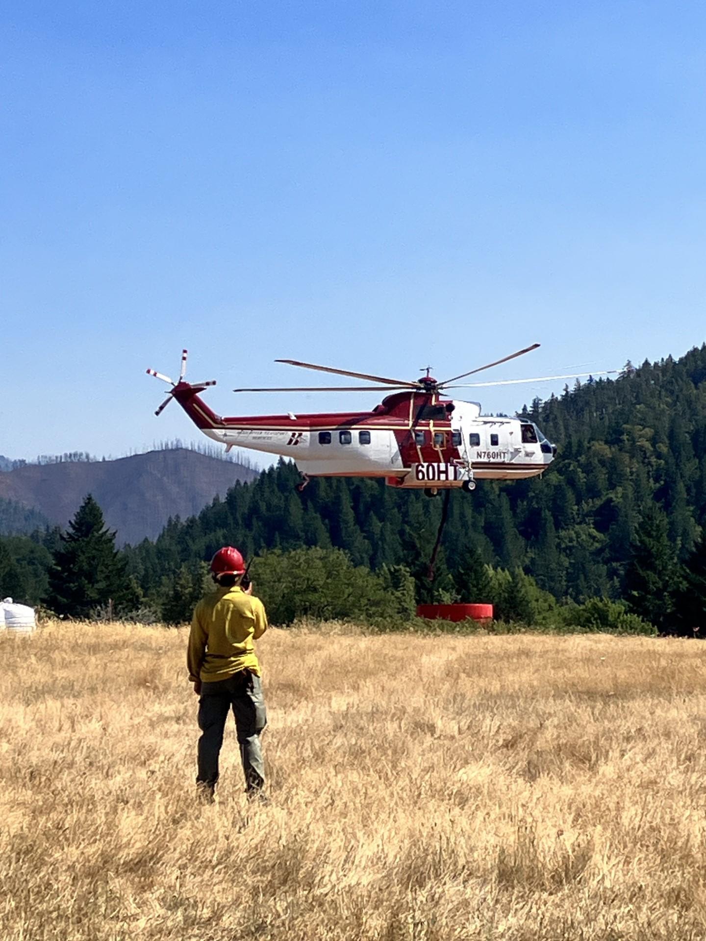 A type 1 helitanker using a snorkel to fill up with retardant at Mobile Retardant Base July 27, 2023