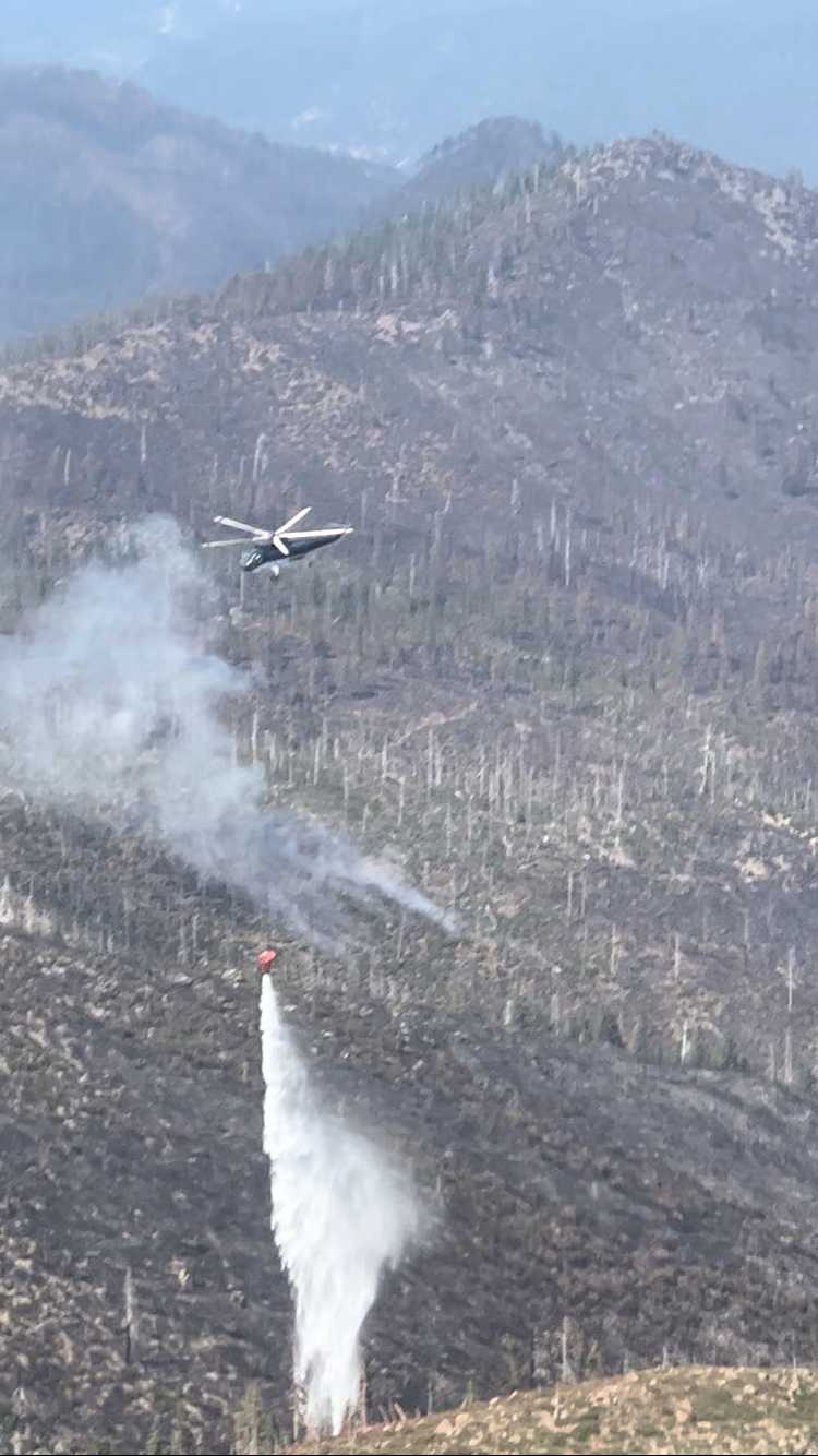 Helicopter dropping water on the fire area