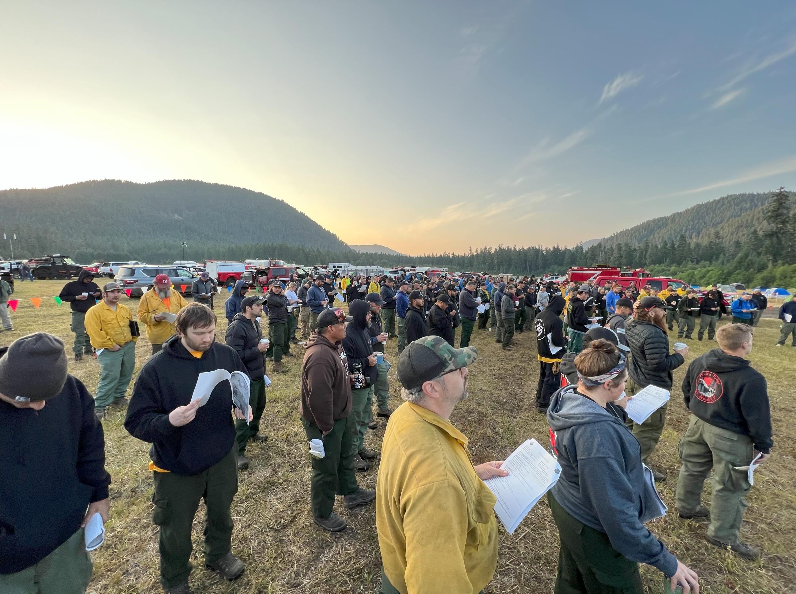 Fire personnel gather shortly after sunrise for morning briefing.