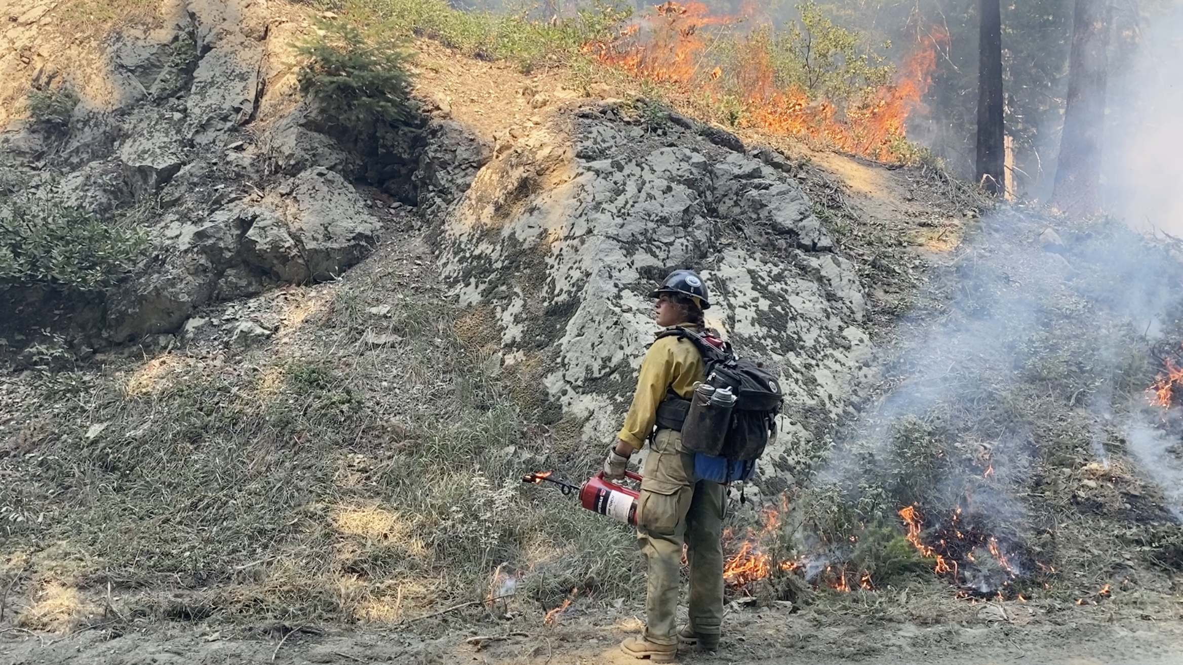 A Vale IHC member holds a drip torch during a firing operation