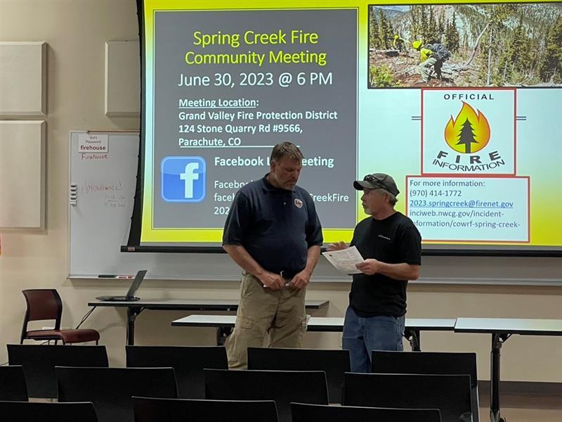 Planning ops Deon Steinle speaks with a community member following the June 30 community meeting.