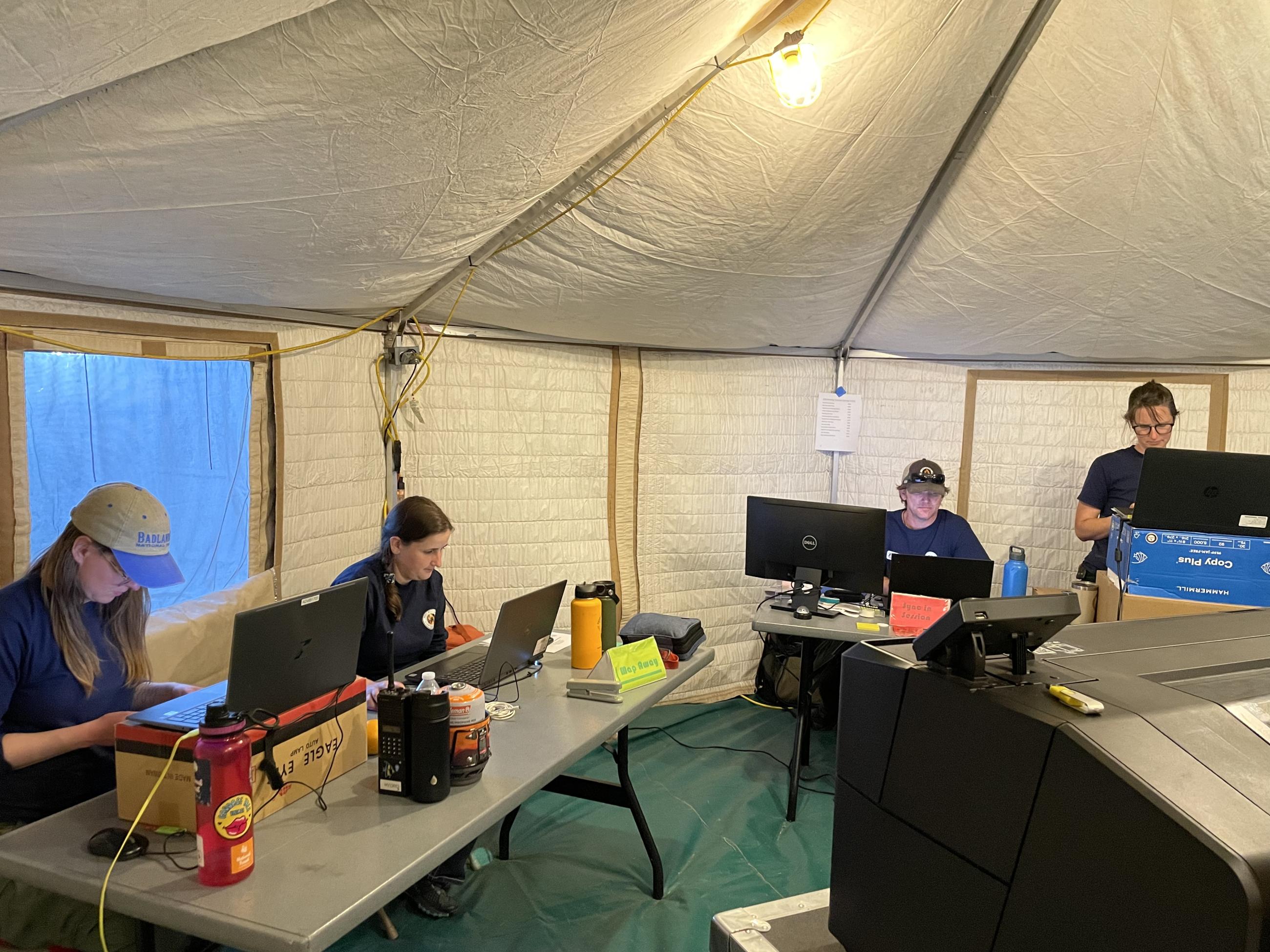 4 people on computers creating maps for incident personnel