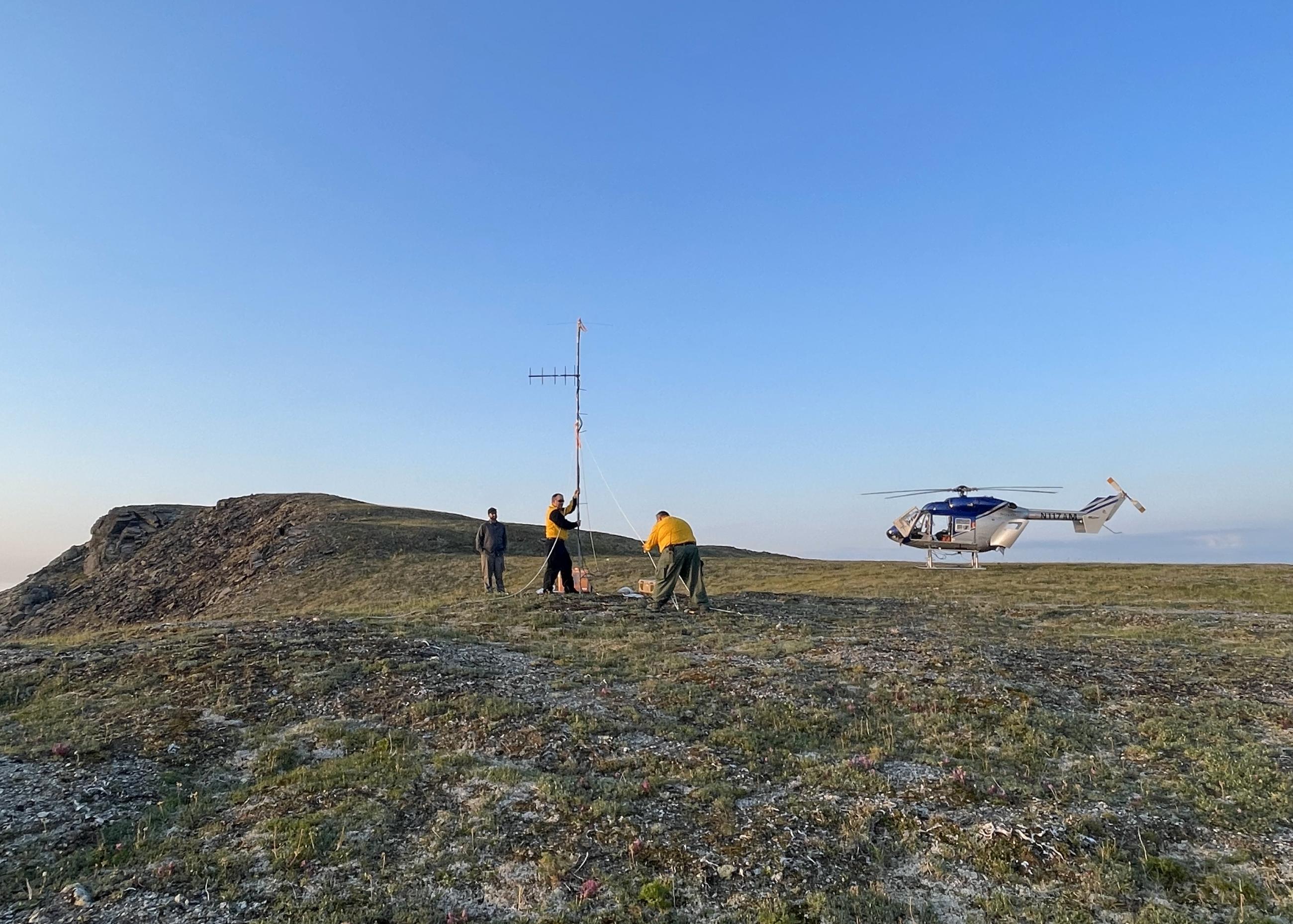 A radio crew on the Anderson Complex establishes a radio repeater site for firefighters on the Anderson Complex. A helicopter sits on the ridge in the background.