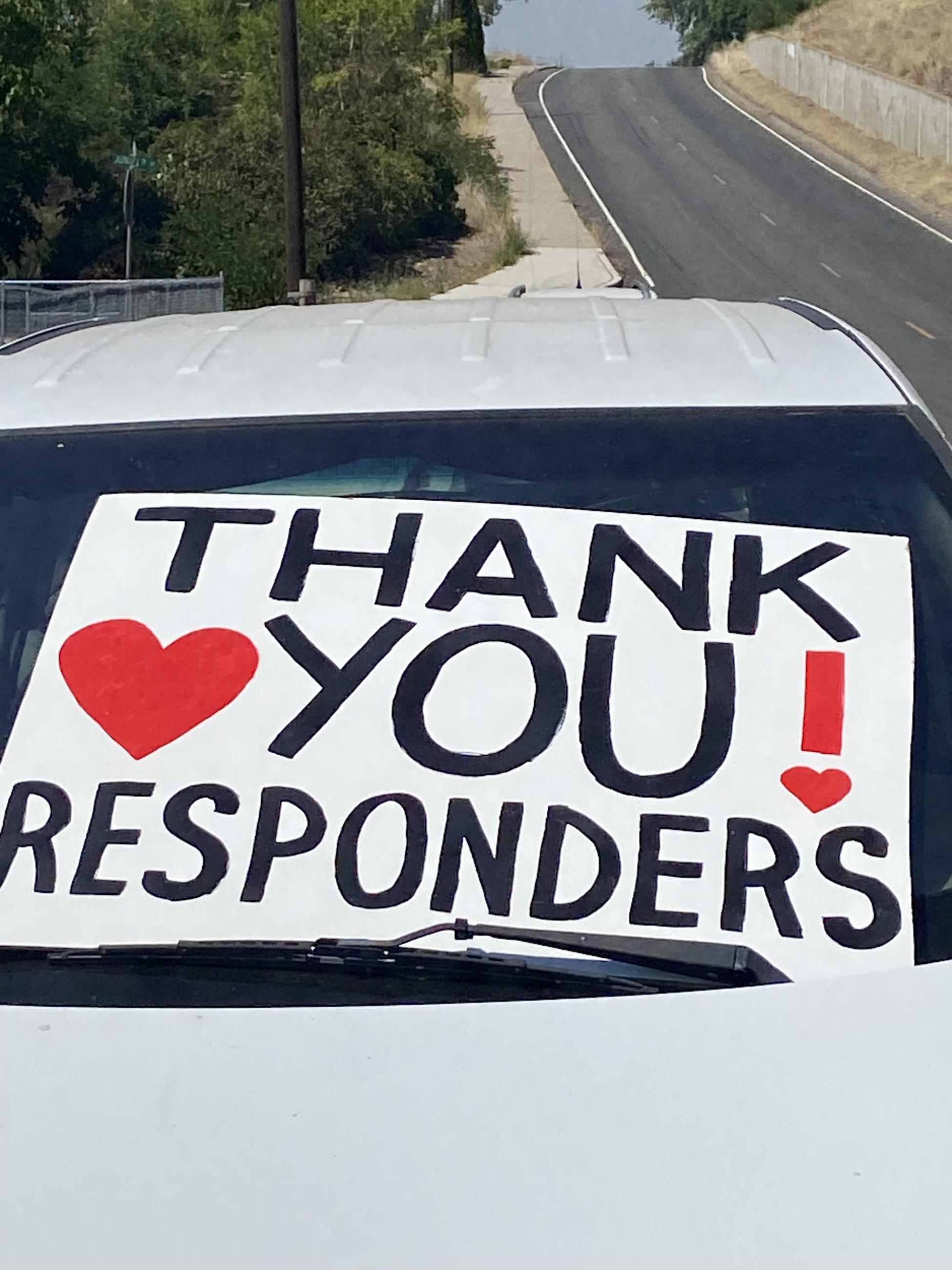 A sign that someone has placed in the windshield of their car reads "Thank you responders" with hearts.