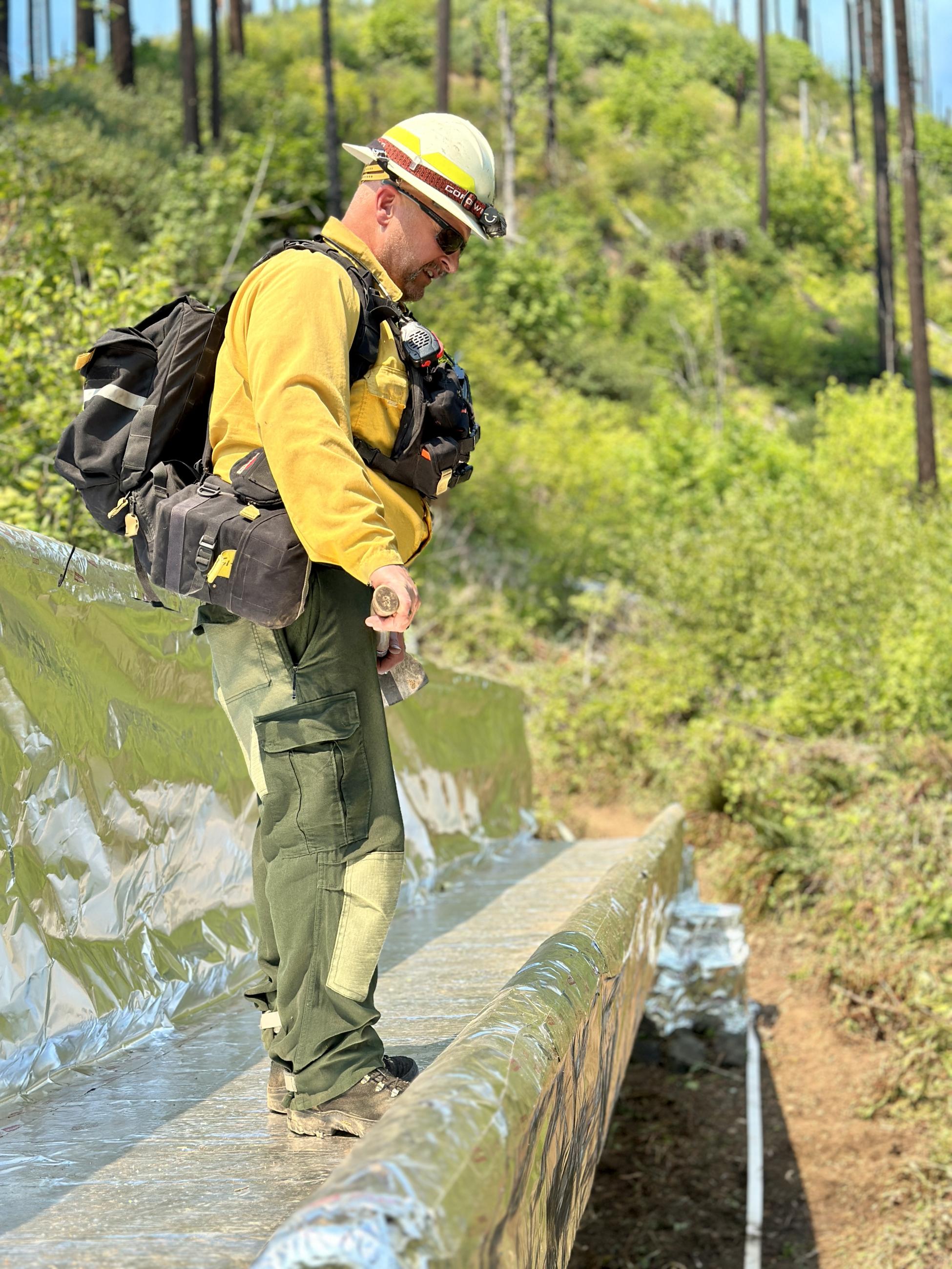 The Sierra/Yankee Division Supervisor inspects a bridge protected by aluminized structure wrap at Bedrock Campground.