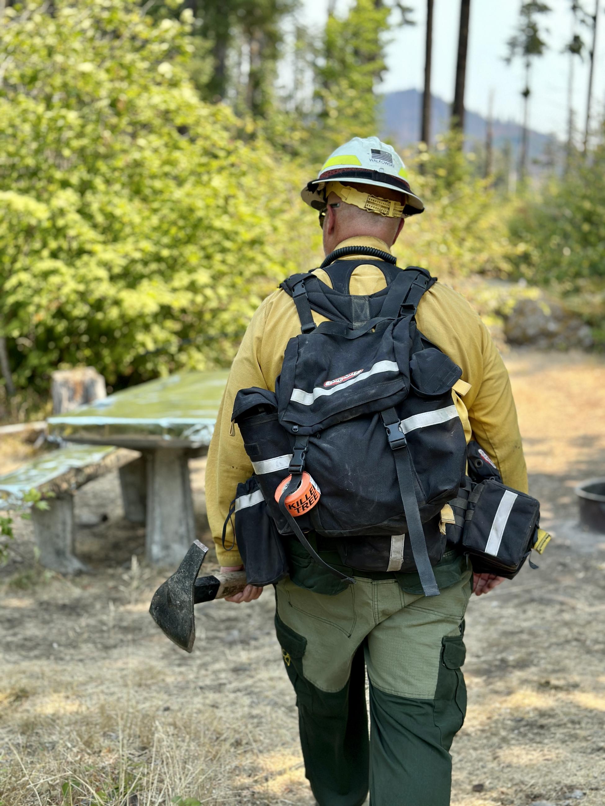 The Sierra/Yankee Division Supervisor walks towards a picnic table protected by aluminized structure wrap at the Bedrock Campground.