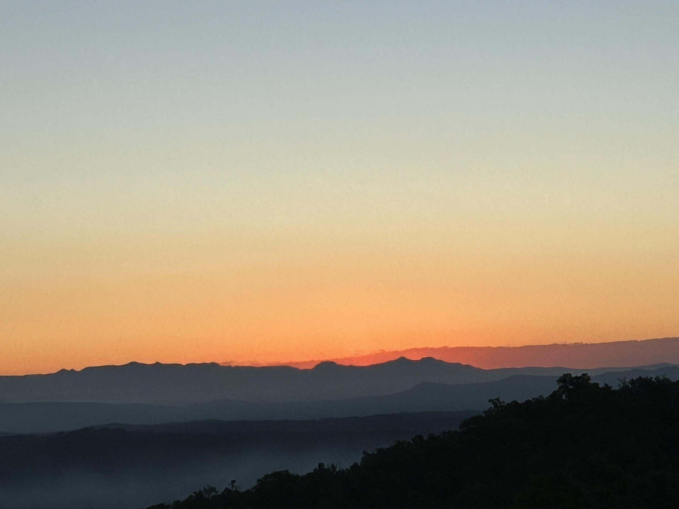 A hazy sunrise in a mountainous area.