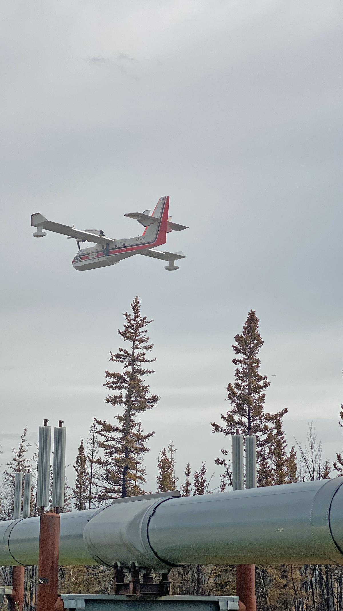 A Superscooper flies near the Pipeline after dropping water on the west flank of the Pogo Mine Road Fire