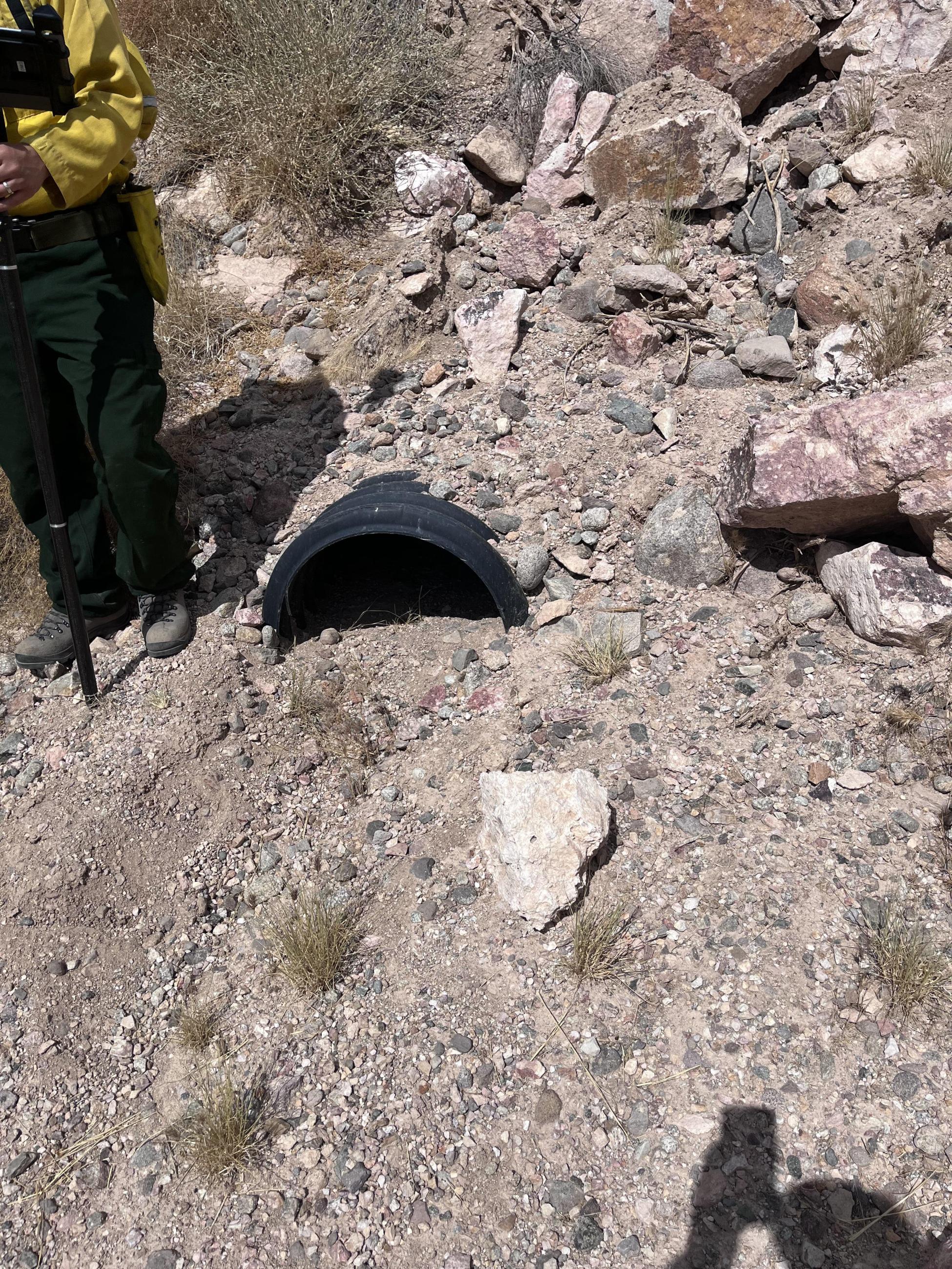 A USFWS scientist measures debris in a culvert after the York Fire 8/14/23