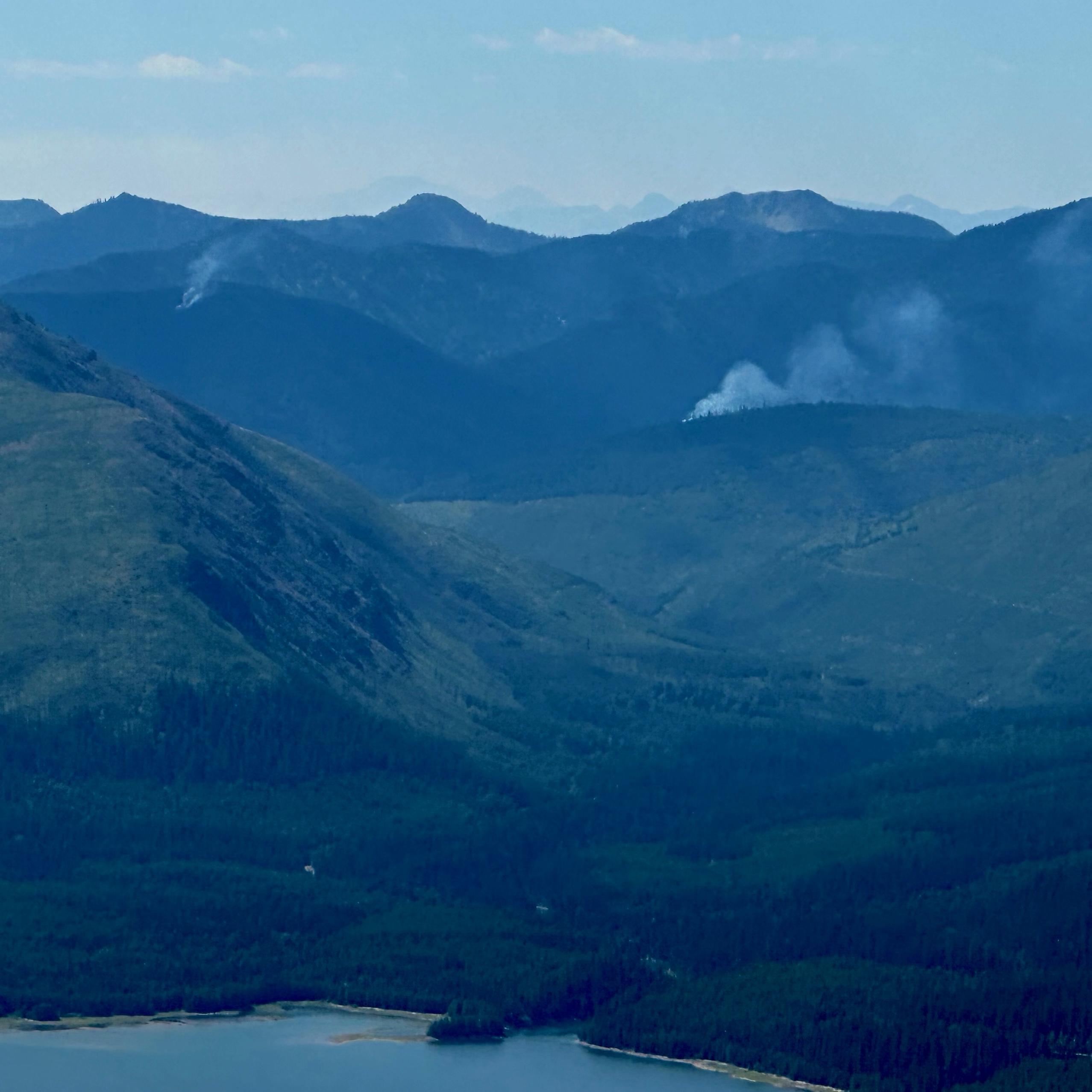 Mountain landscape with Kah Fire in lower right frame, Sullivan Fire on the left side of the frame, and Con Kelly Fire near the top of the ridge above Kah Fire.