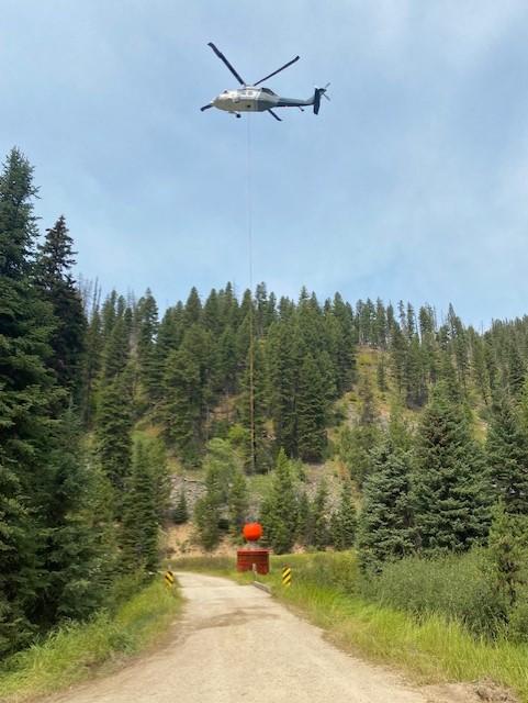 The helicopter dips water from a heliwell to dump on the Bowles Creek Fire on August 16, 2023. Photo by A view of fire operations along from Hwy 38 on August 16, 2023. Photo by Jared Culbertson_USFWS