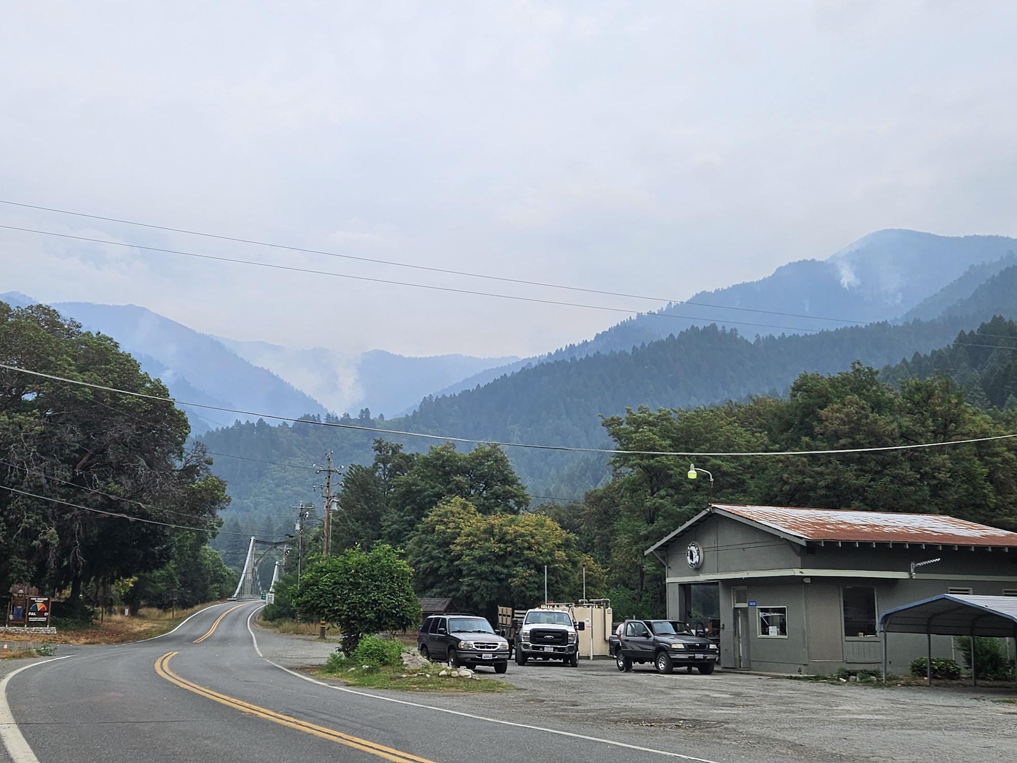 A garage with several mountains in the background obscured by smoke