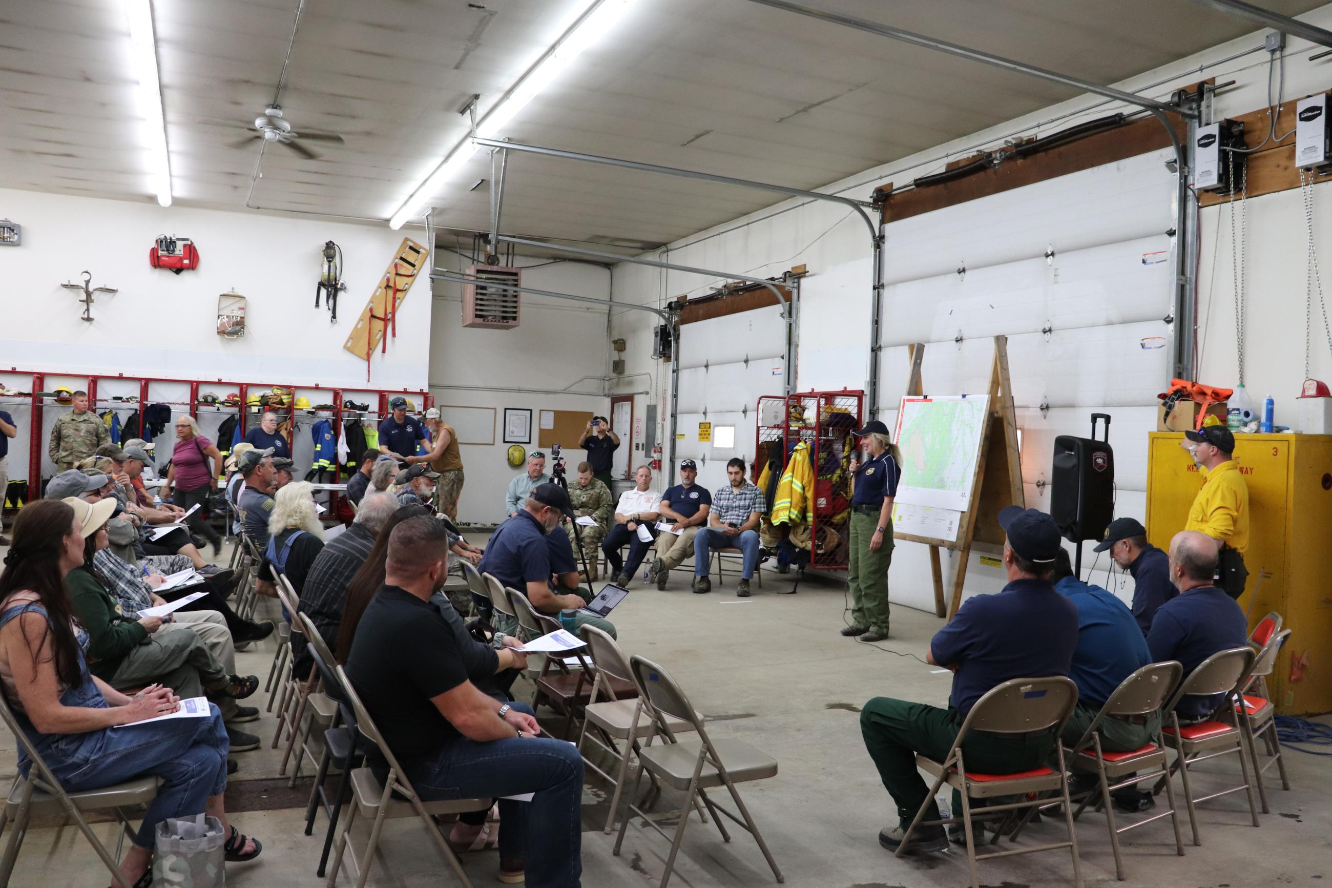 Anderson Complex public meeting held in the Anderson Fire Department engine bay, August 2, 2023. Public Information Officer, Robbie Johnson addresses the crowed engine bay, and sets the stage for presentations by various members of the incident management team and local officials. The meeting was streamed live on Facebook as well. 