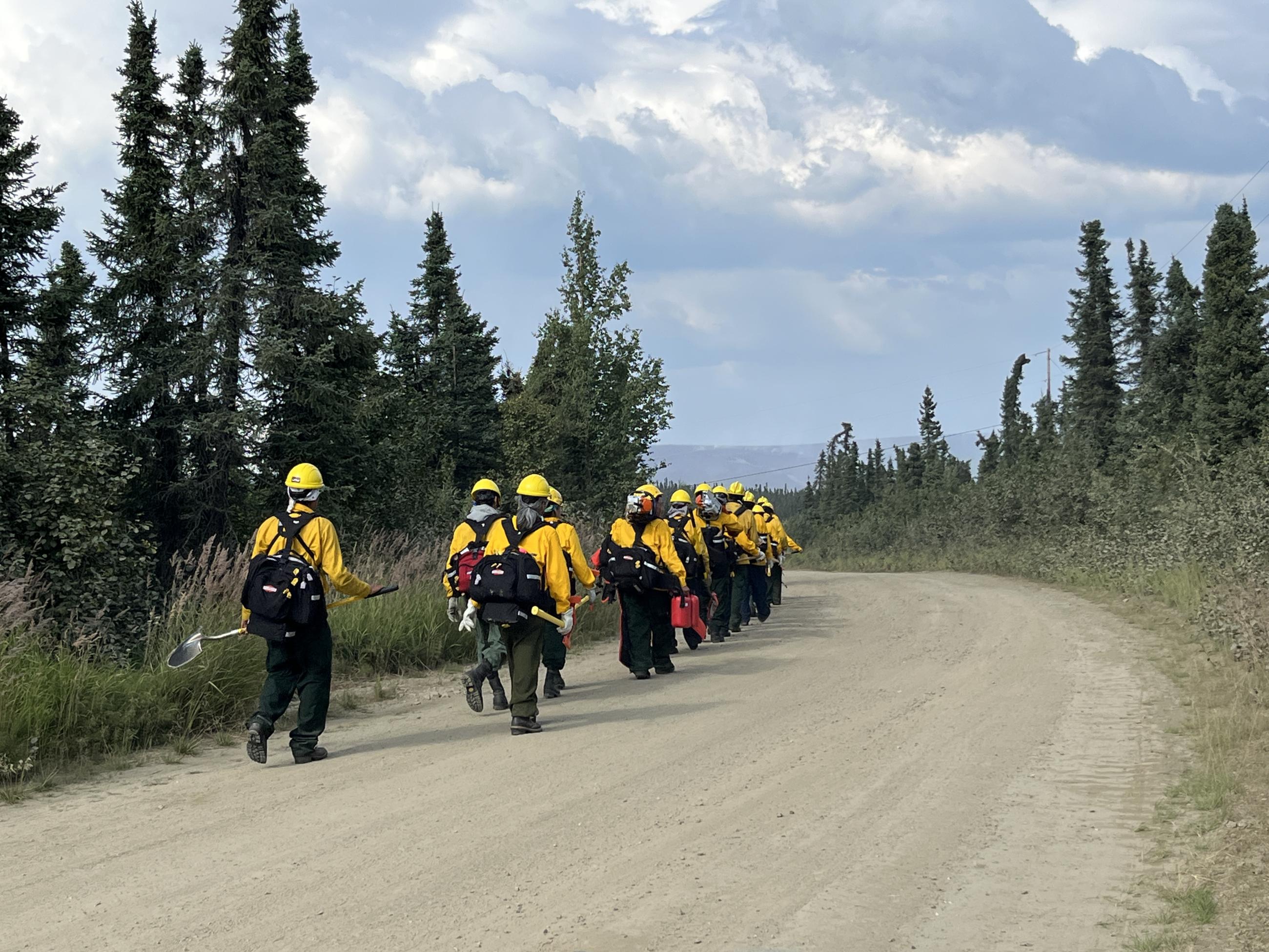 A crew of firefighters walks away.