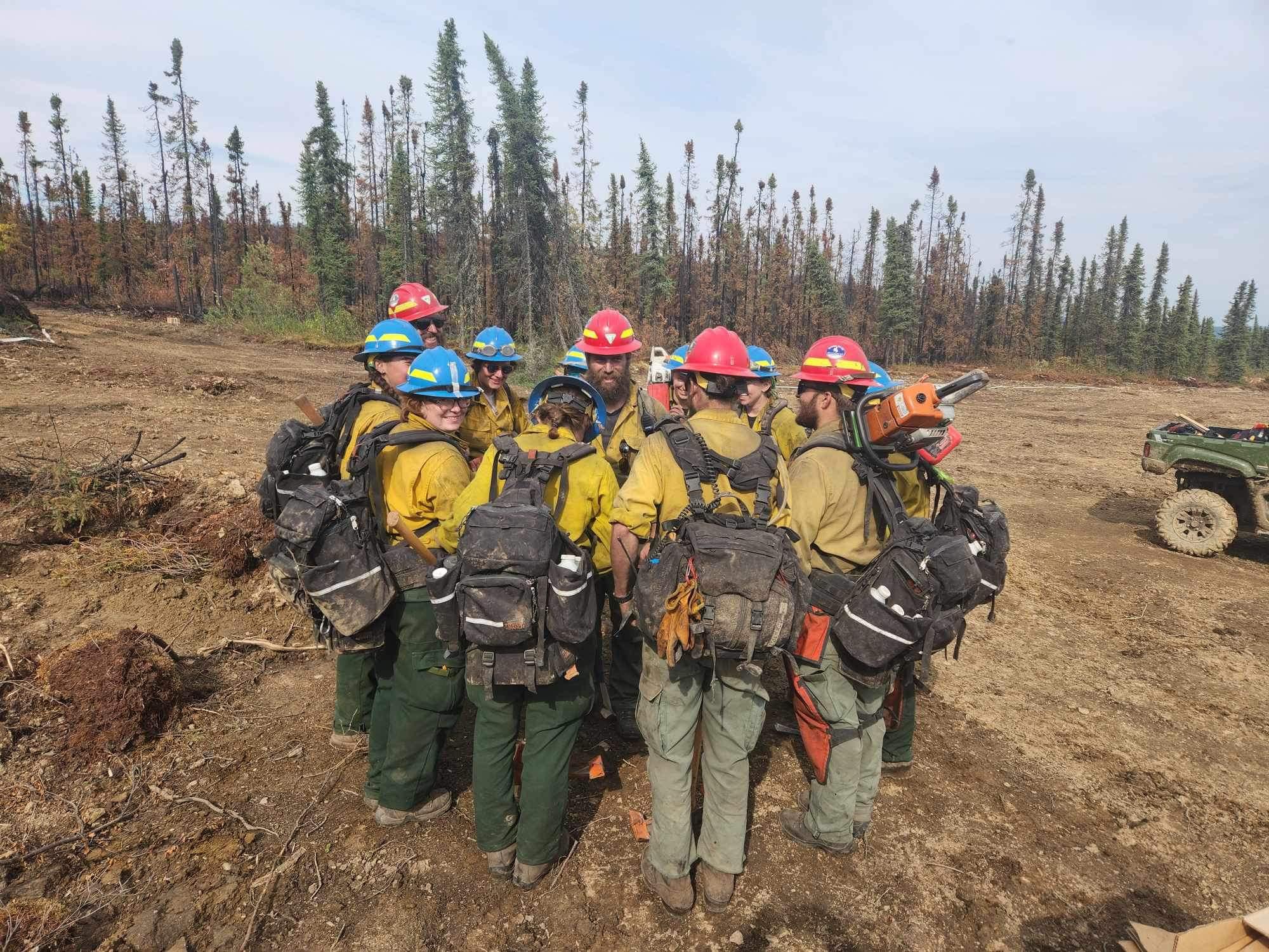 A group of firefighters in a huddle.