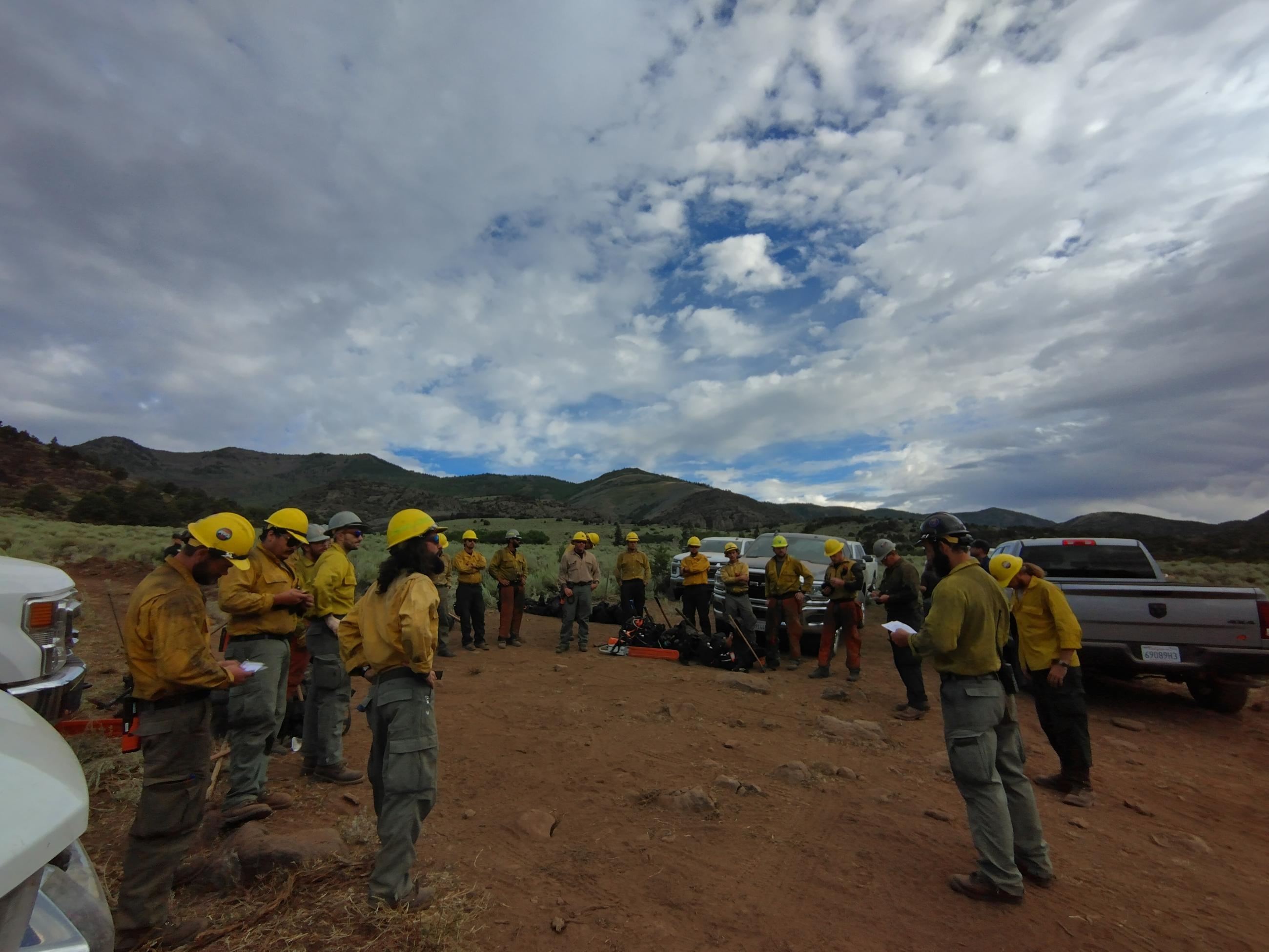 firefighters circled around to brief before hiking