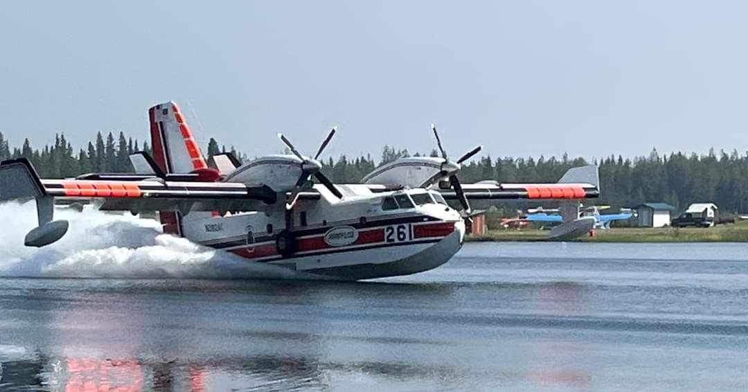 A scooper plane skims the water.