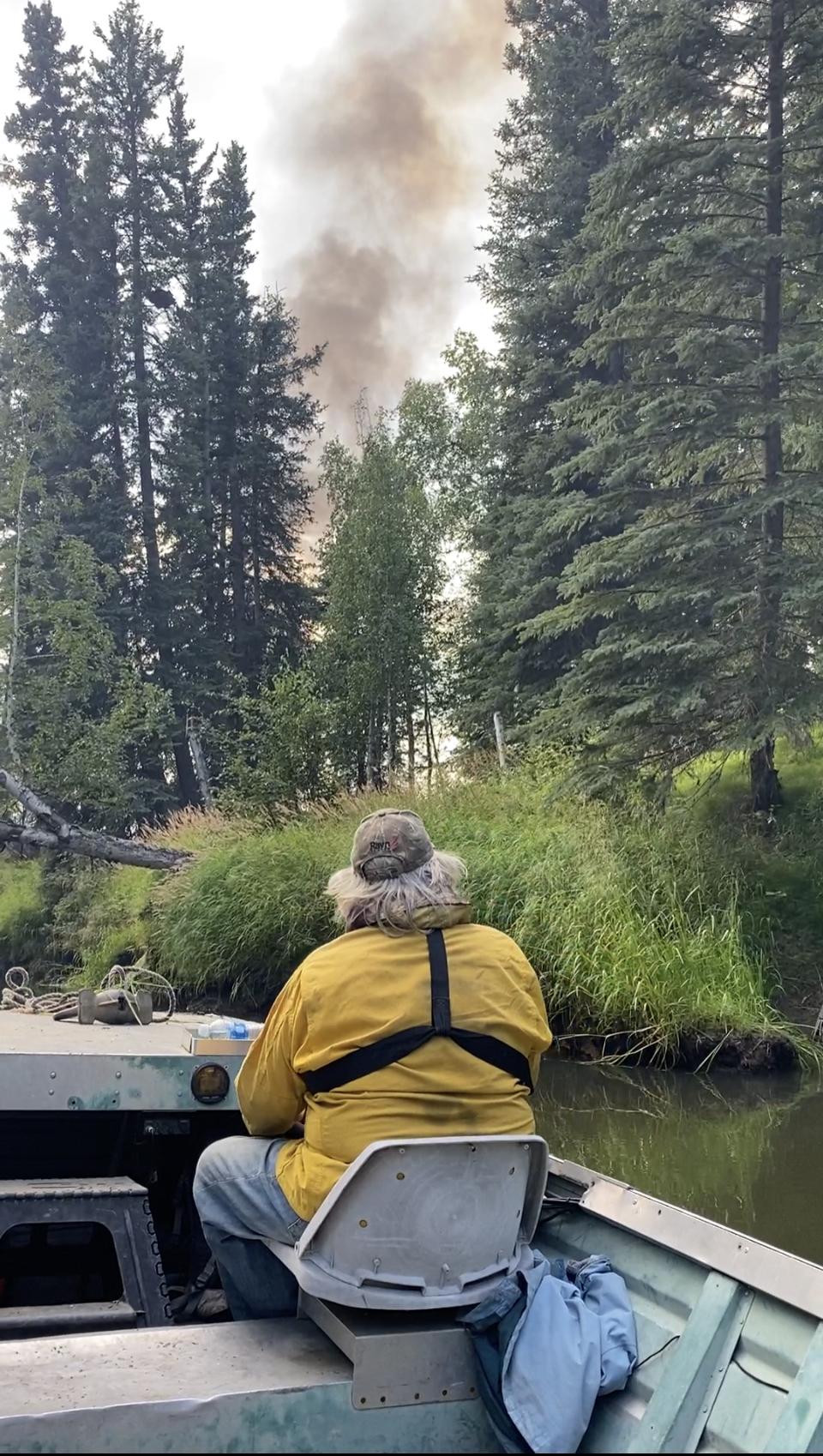 Boat operator transports firefighters on the Pogo Mine Fire