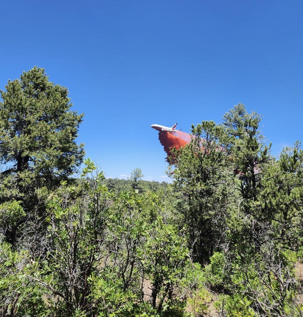 Photo of a plane dropping retardant onto the American Mesa Fire