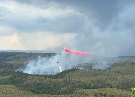 An airtanker drops fire retardant over the Snake Ridge fire on July 28, 2023 in initial attack