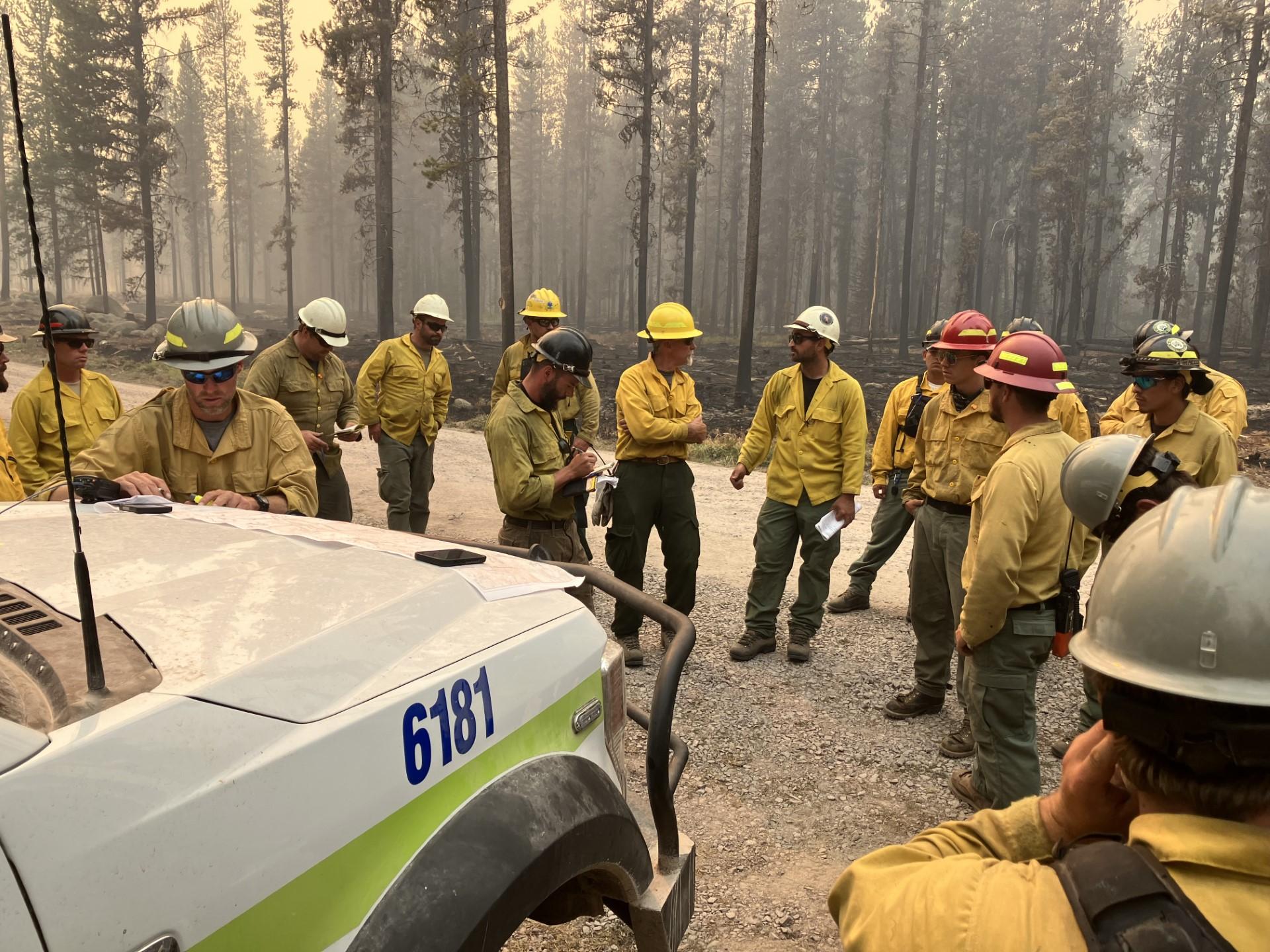A U.S. Fish and Wildlife Service fire crew receives a briefing before heading out to the Bowles Creek Fire fireline.