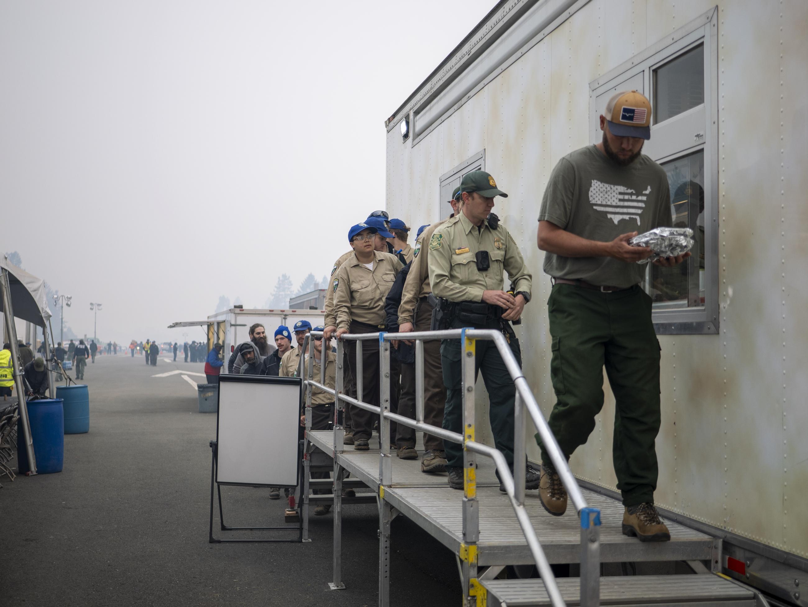 Firefighters line up for breakfast at Gasquet Fire Camp. August 24, 2023