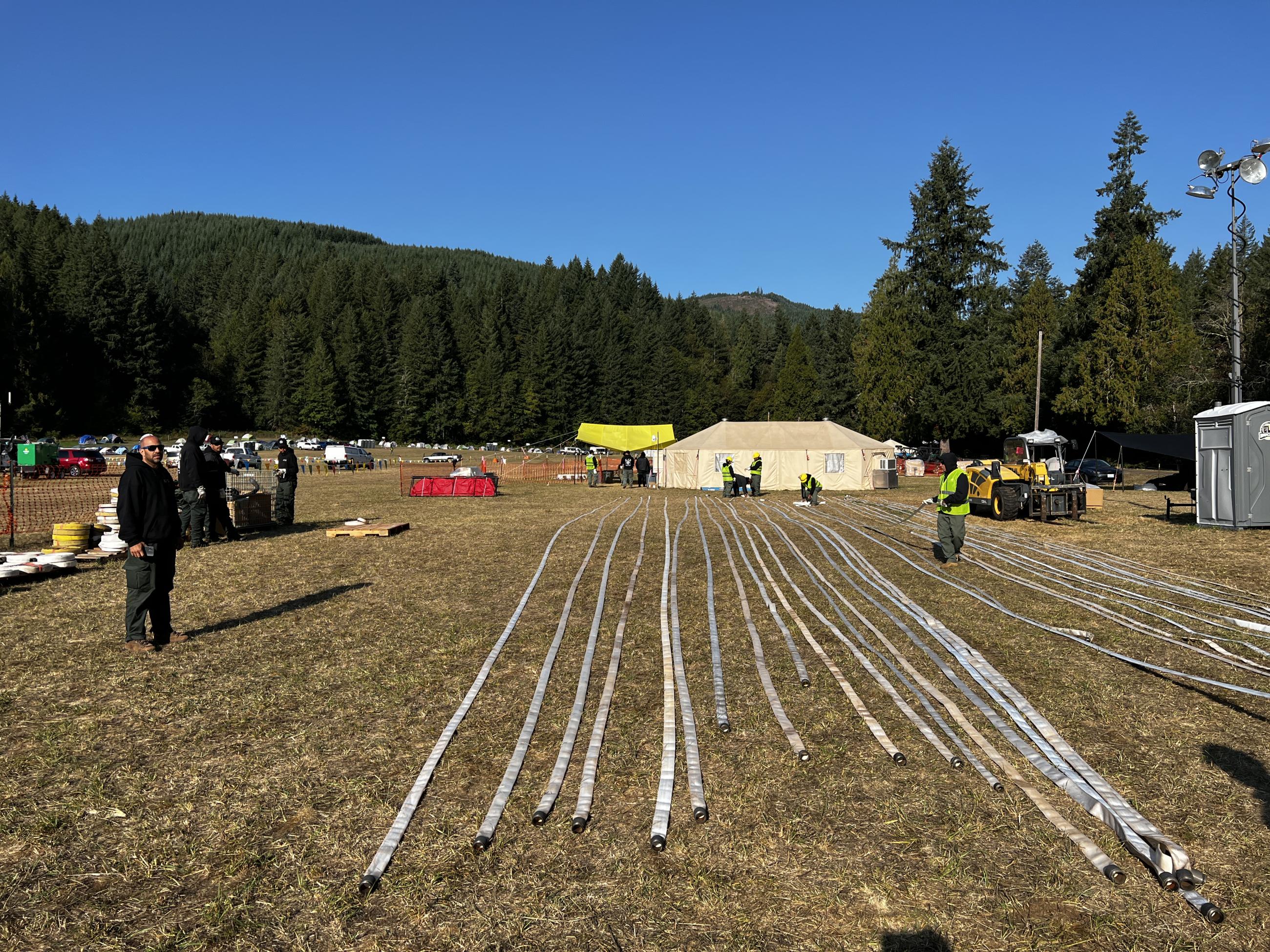 Over two dozen firefighting hoses laid in straight rows