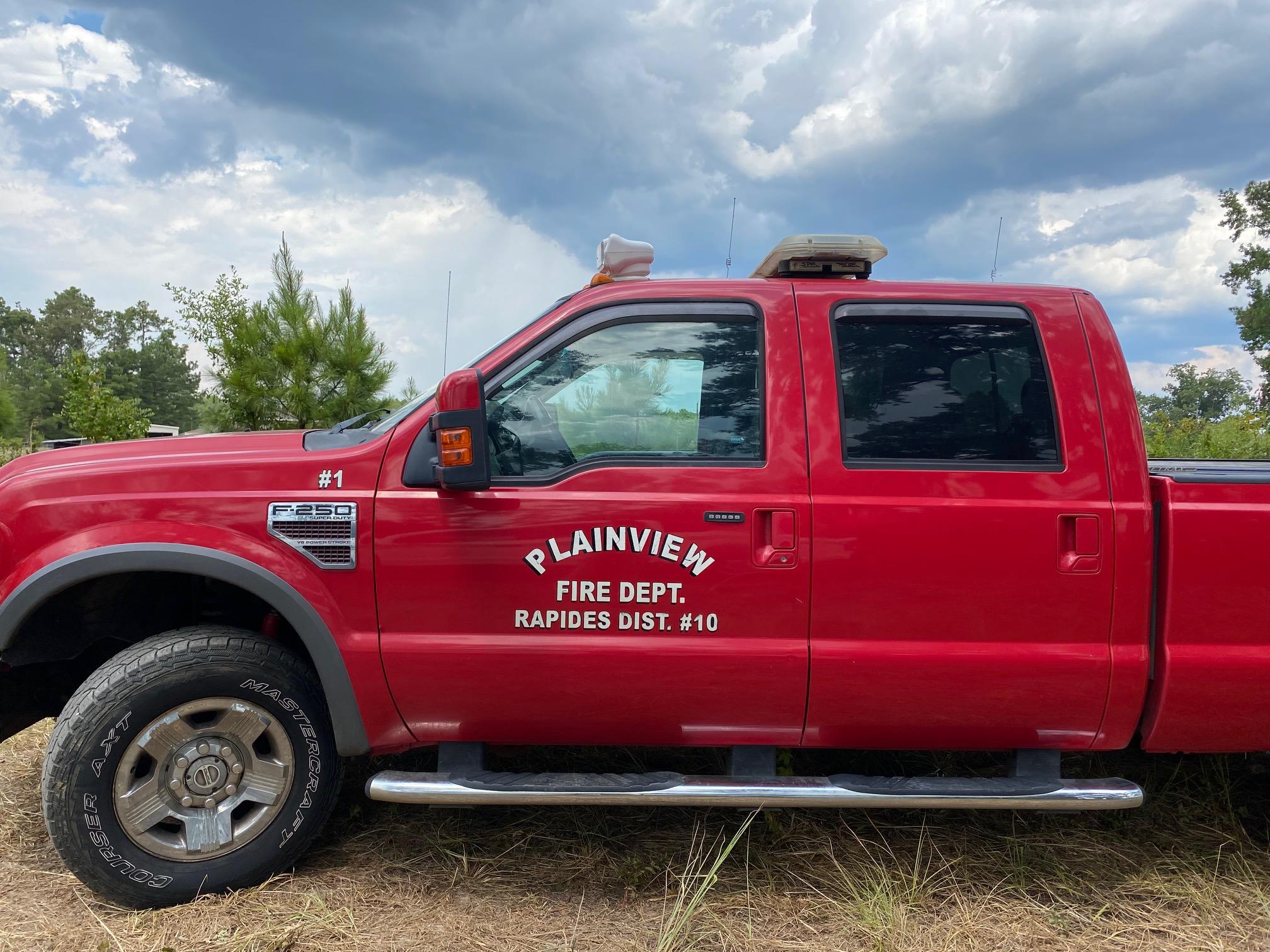 Red fire truck parked with clouds in background