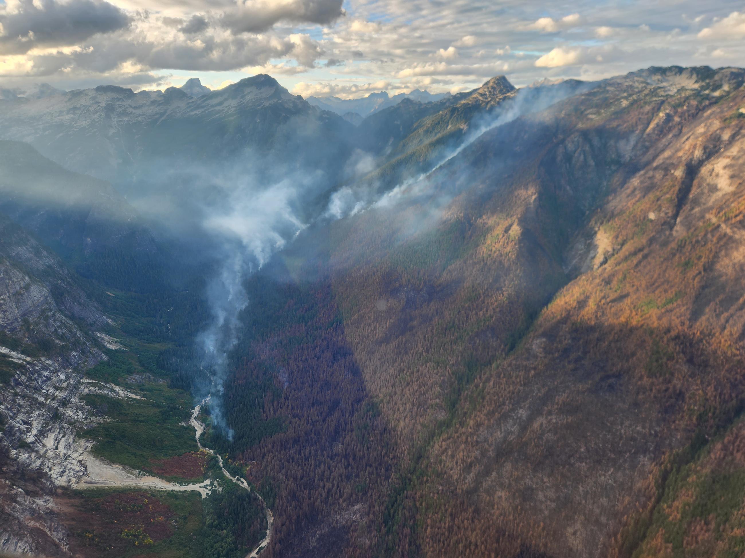 Wisps of smoke in a forested mountain drainage