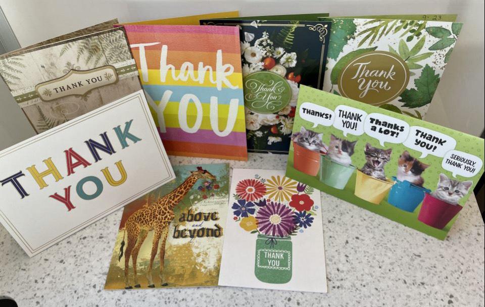 Eight thank you cards displayed on a desk