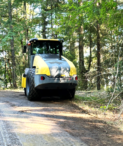 A grader smooths a dirt road