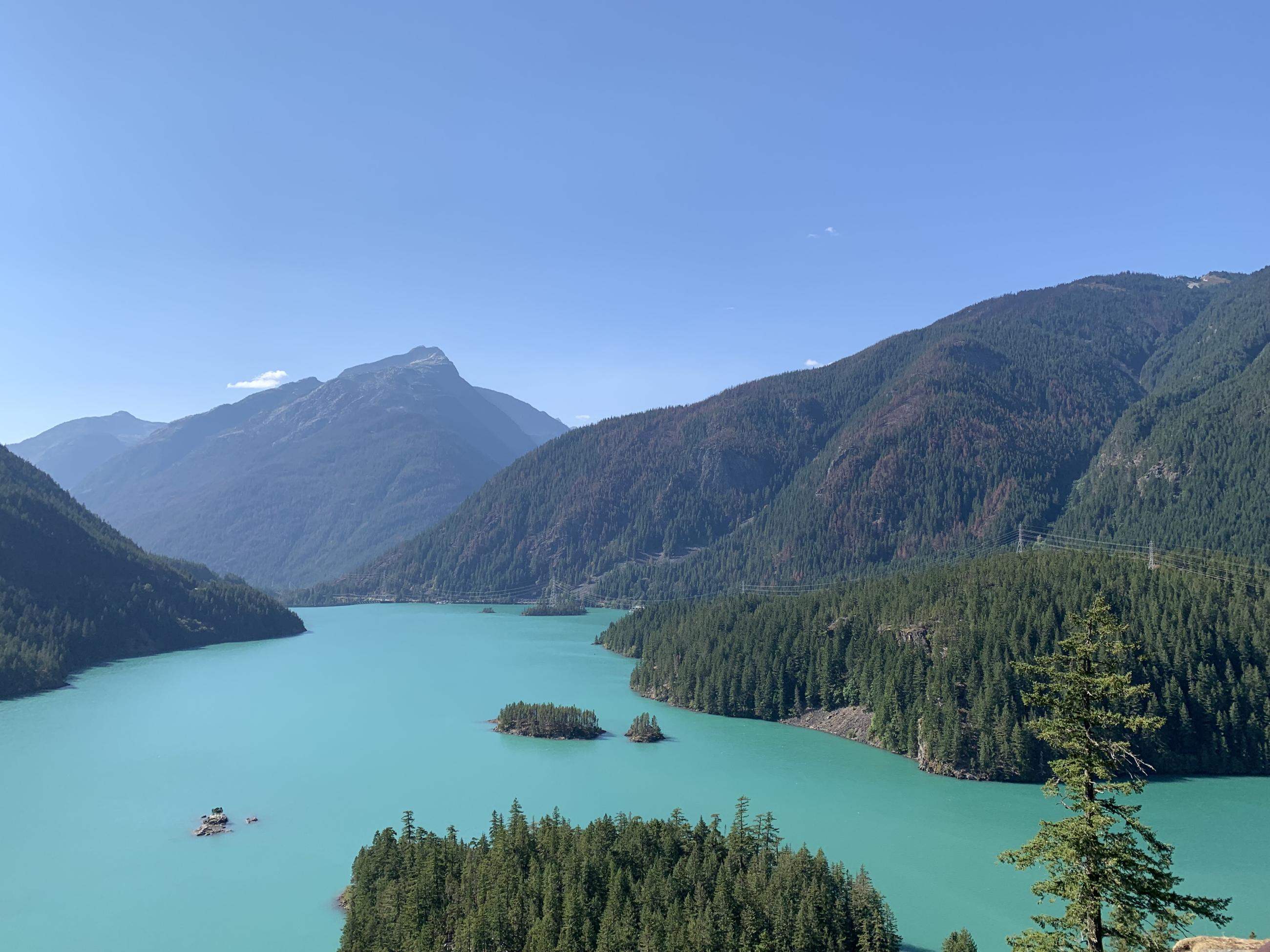 Turquoise green lake with mountains in background