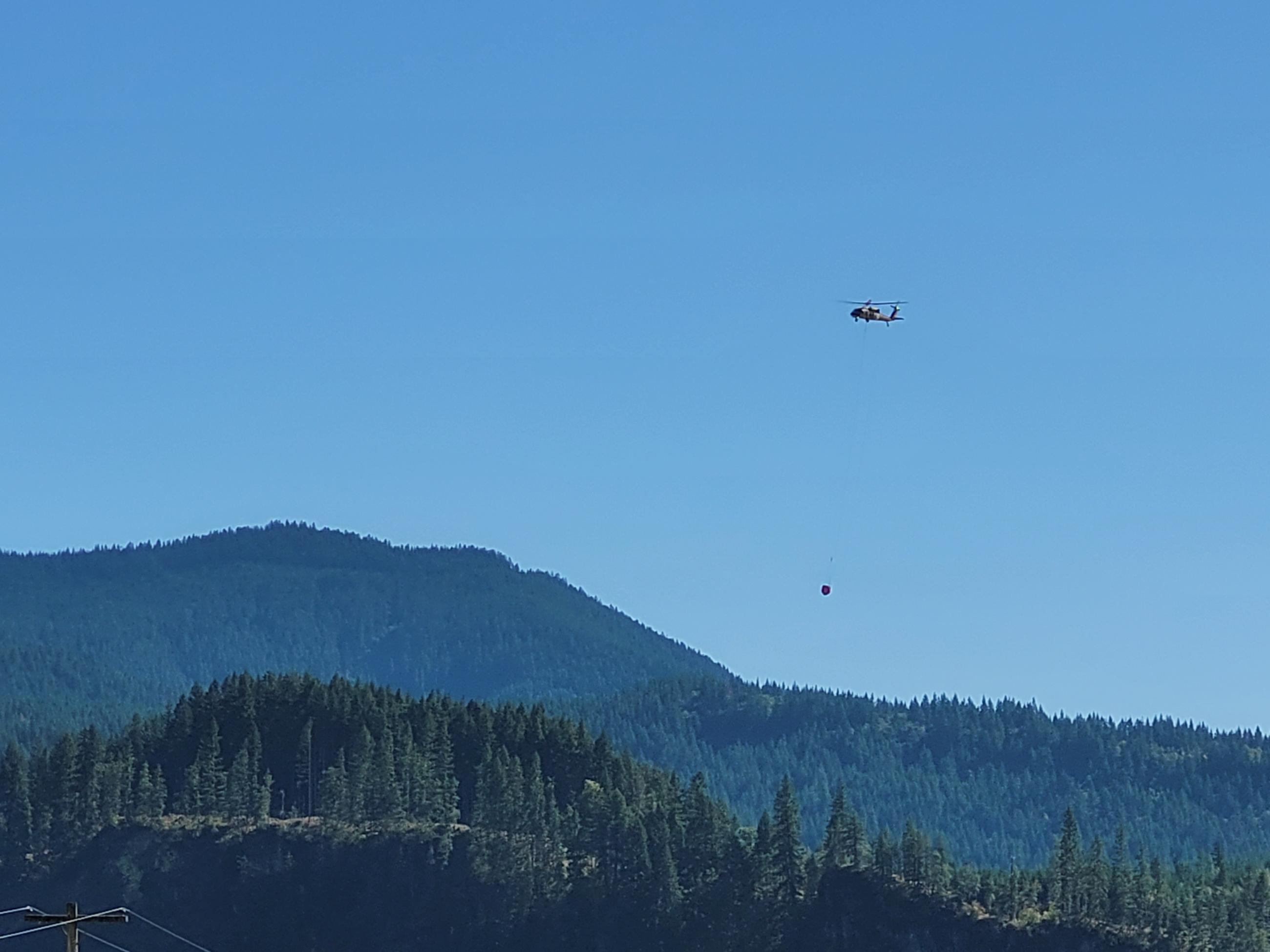 A helicopter hauls water on the Cowlitz Compex