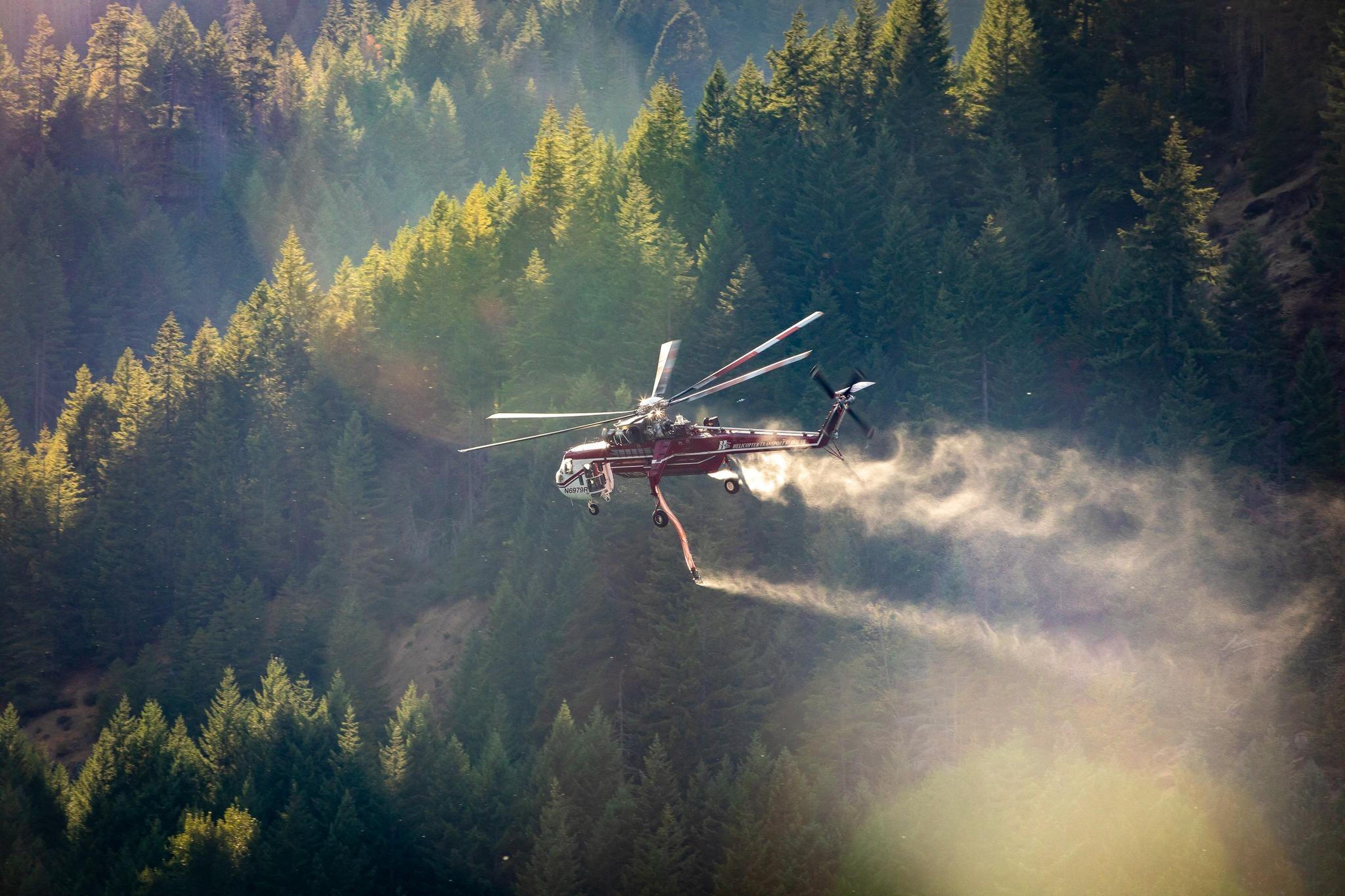 A helicopter drops water onto the fire