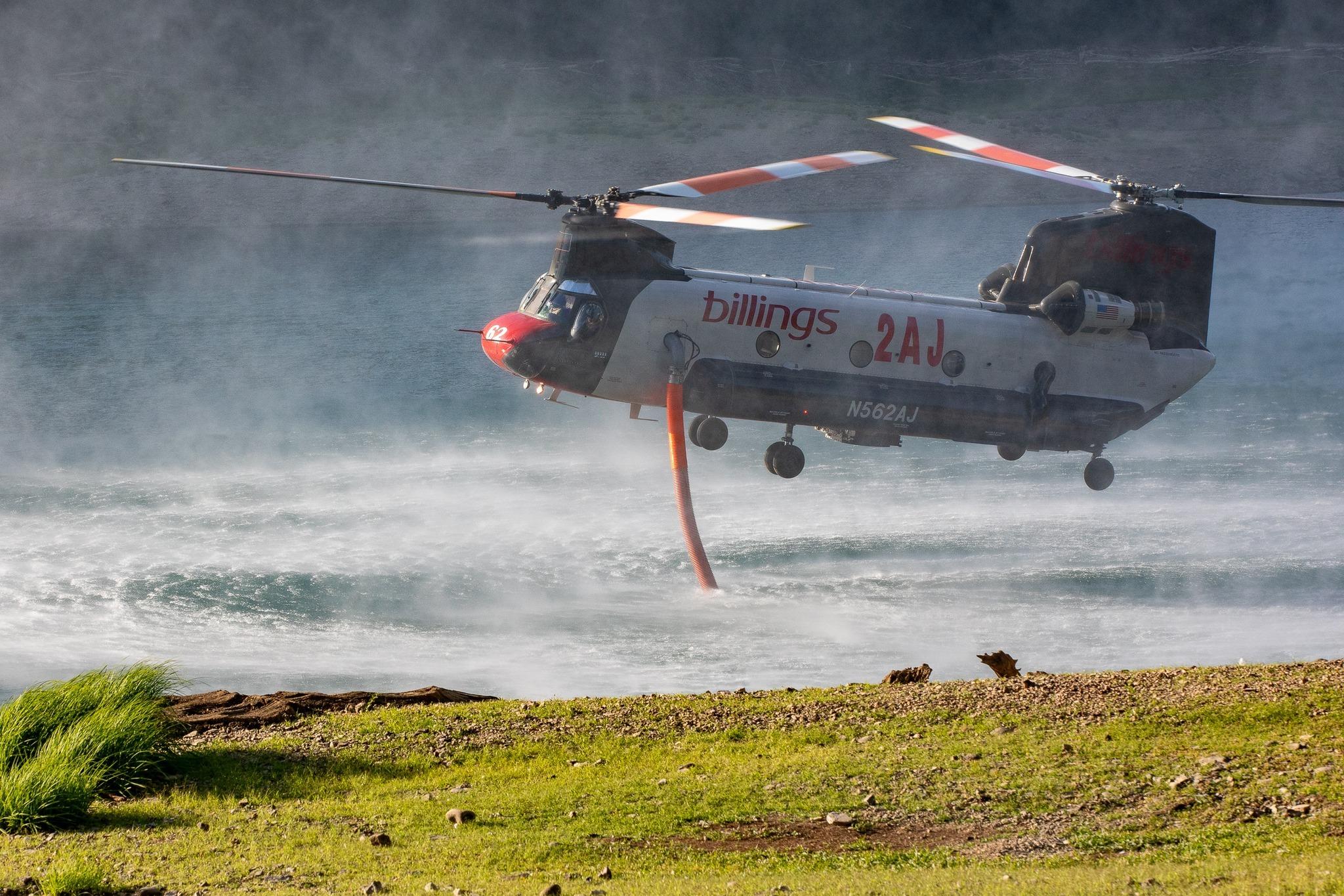 This is a close-up image of a helicopter refilling water from the lake.