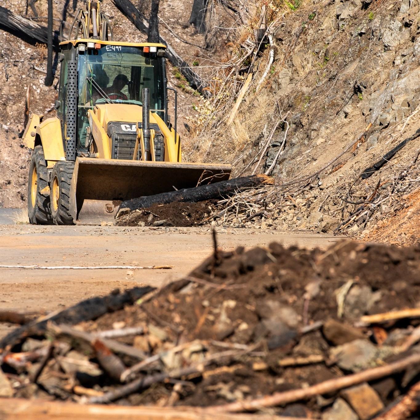A dozer clears the road of debris
