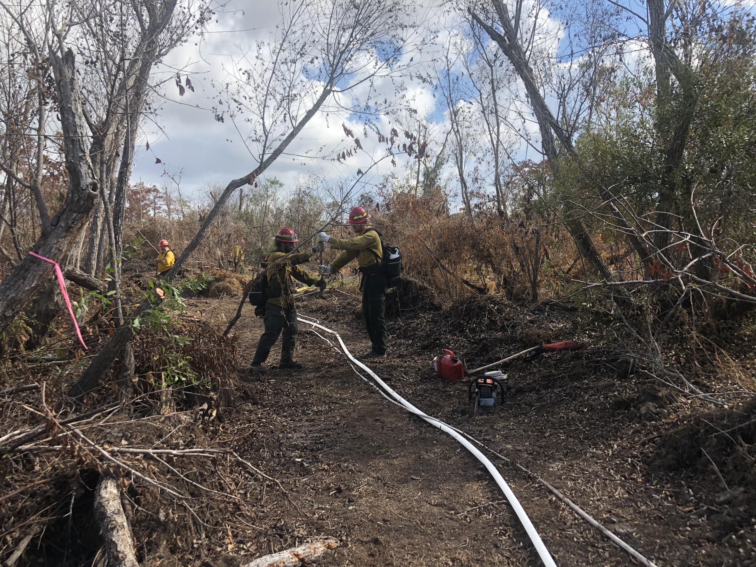 This is an image of firefighters setting up a sprinkler