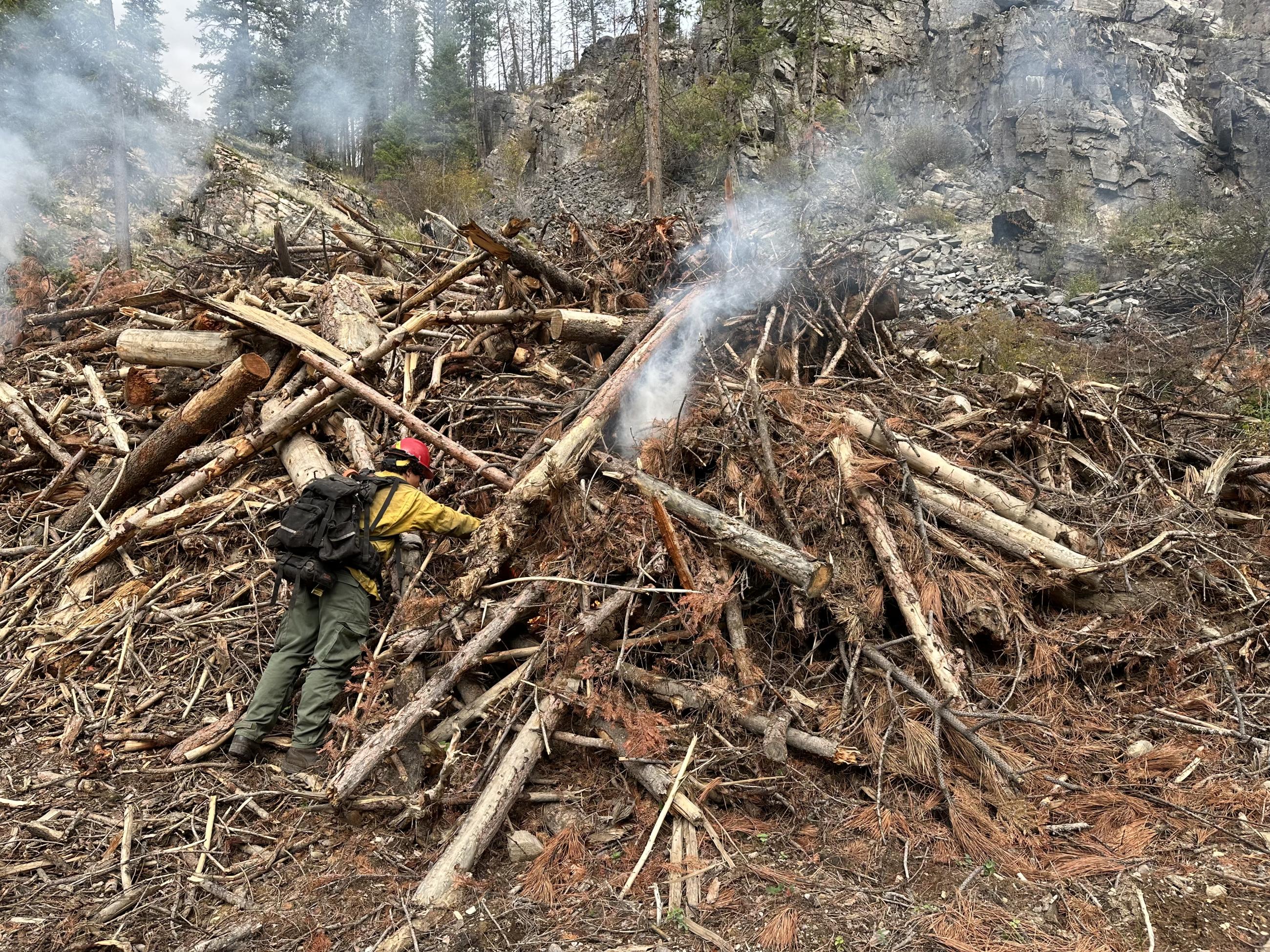 Firefighter igniting a landing pile 