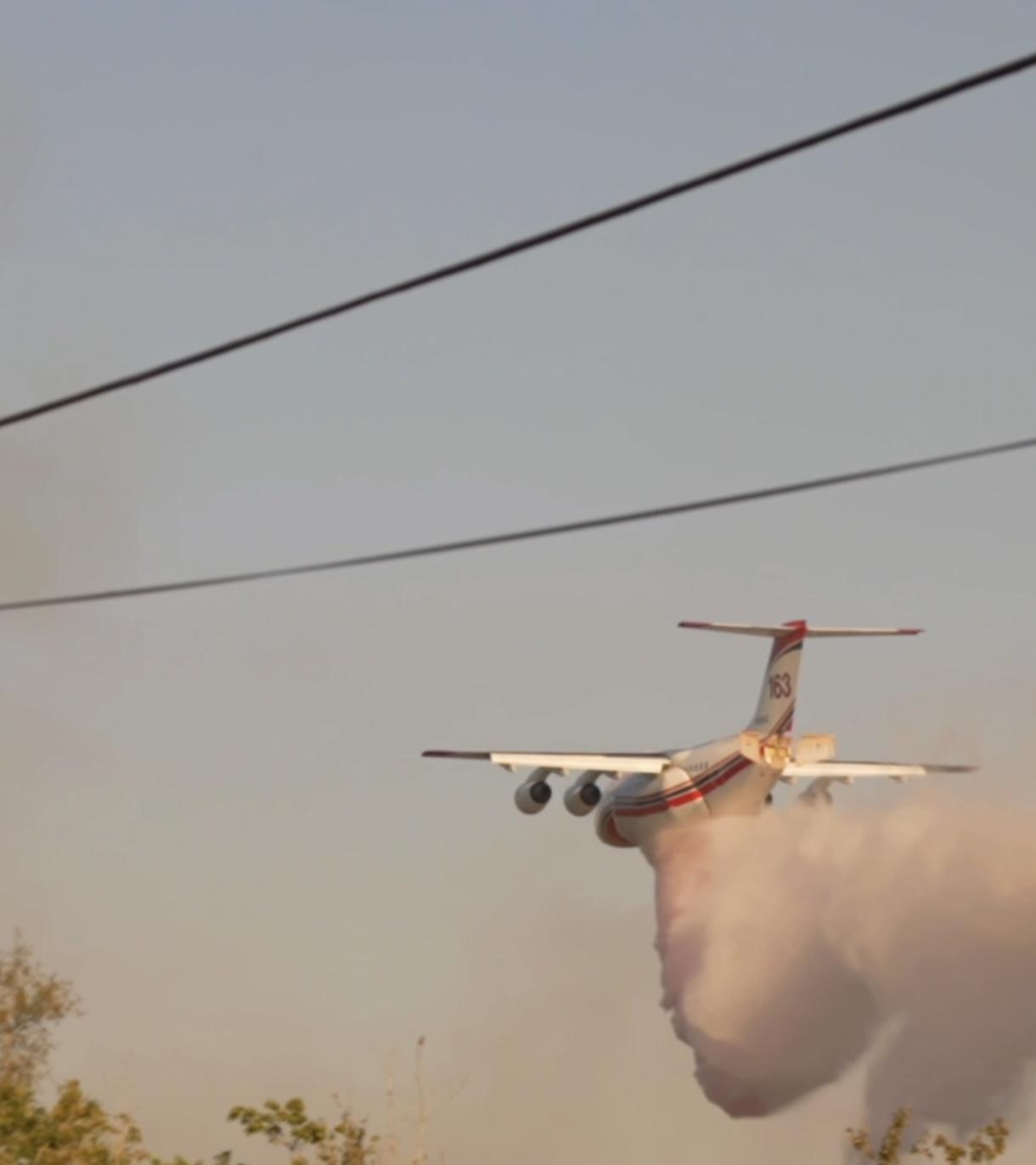 A plane drops water on the fire