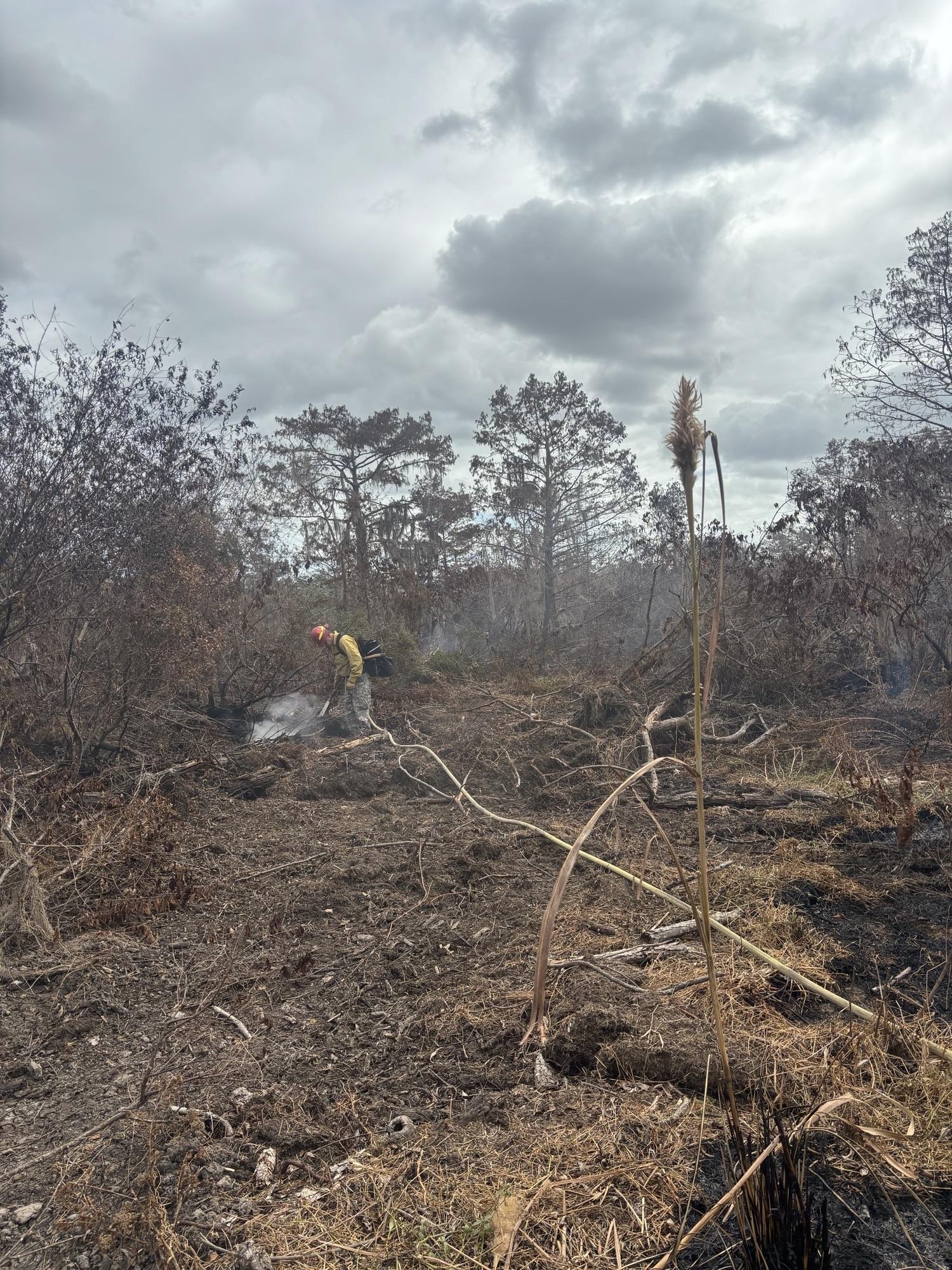 This is an firefighter digging for heat so that he can extinguish it