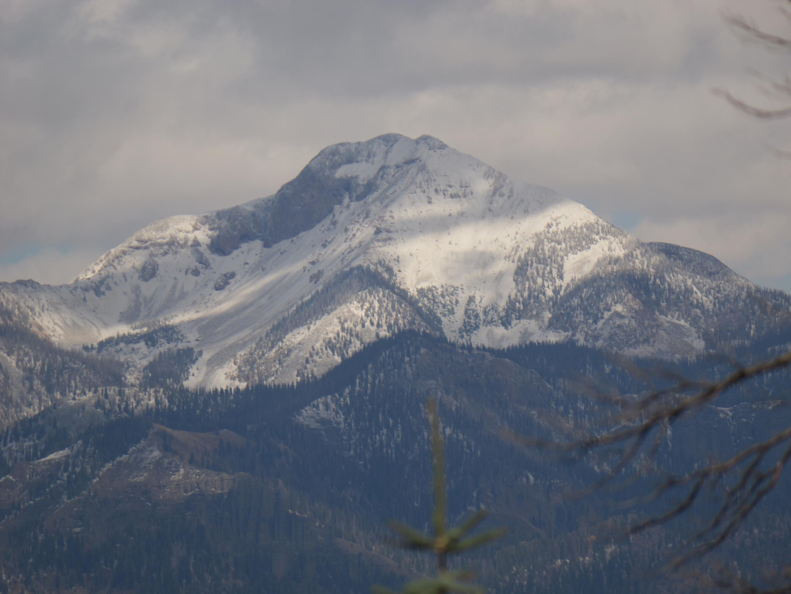 A snow covered paek in the San Juan Mountains as seen from the Trail Springs Fire.