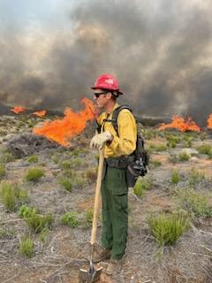 Image of fuels on fire, smoke, and a firefighter working on the Ramona Fuel Break Prescribed Burn.