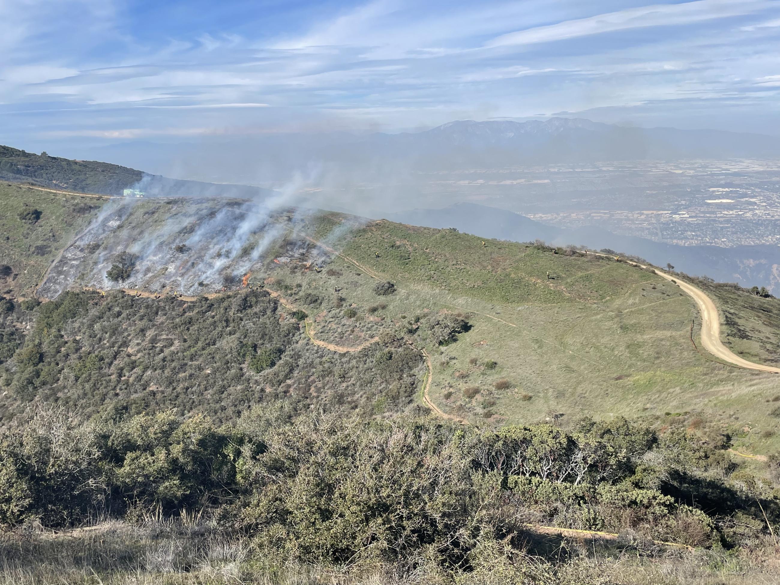 Picture from aerial coverage showing the broadcast burn, firefighters, and hose lays.