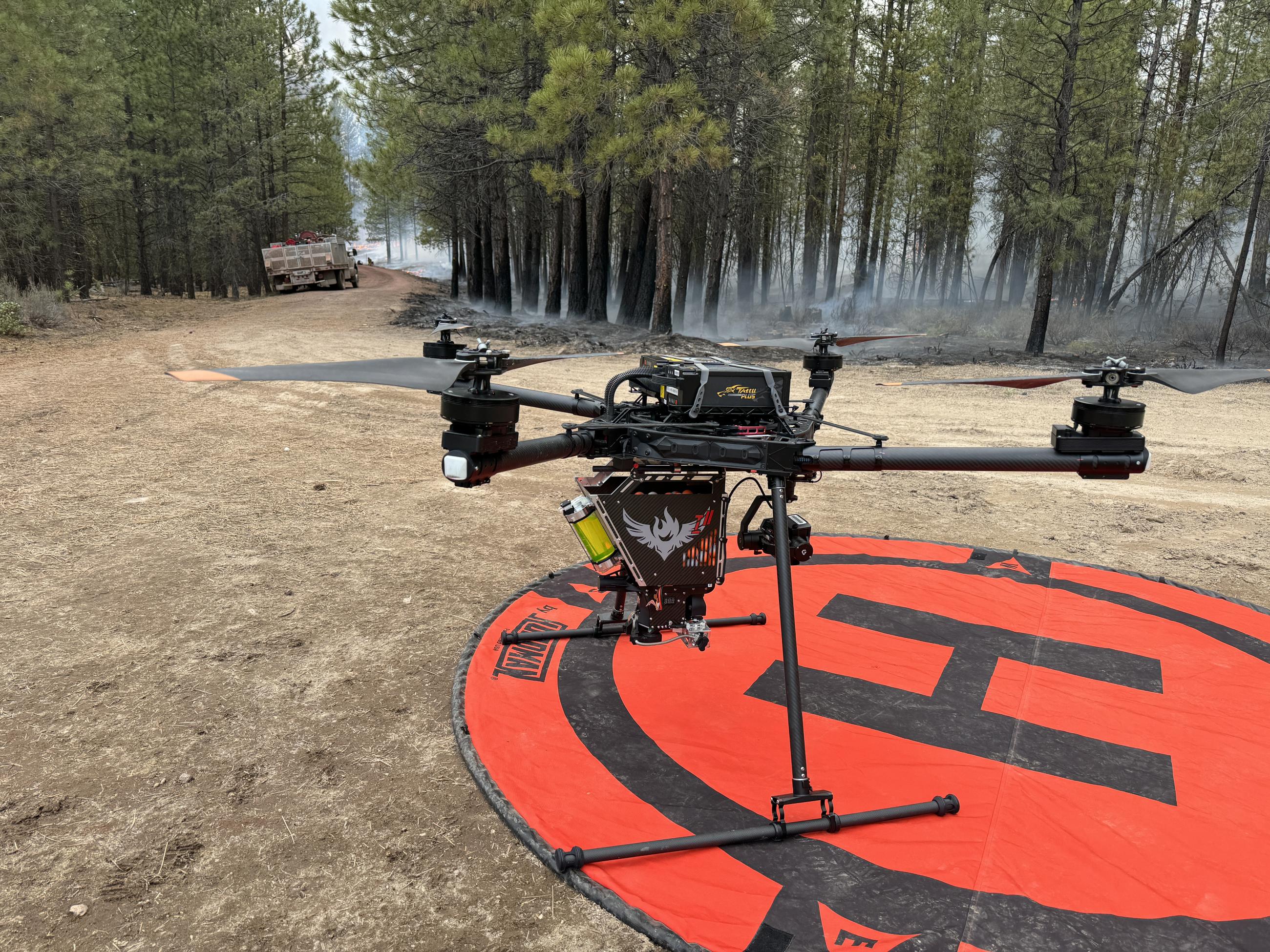 A drone sits on a Heli-pad in the forest