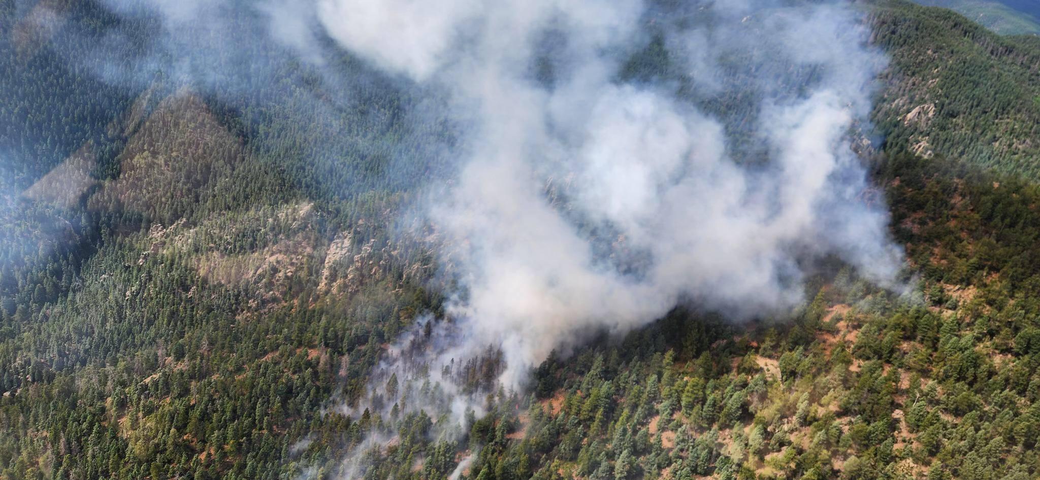 An image of the Oak Ridge Fire the afternoon of June 29, 2024. Smoke rises from multiple points over rolling evergreen covered landscape. 