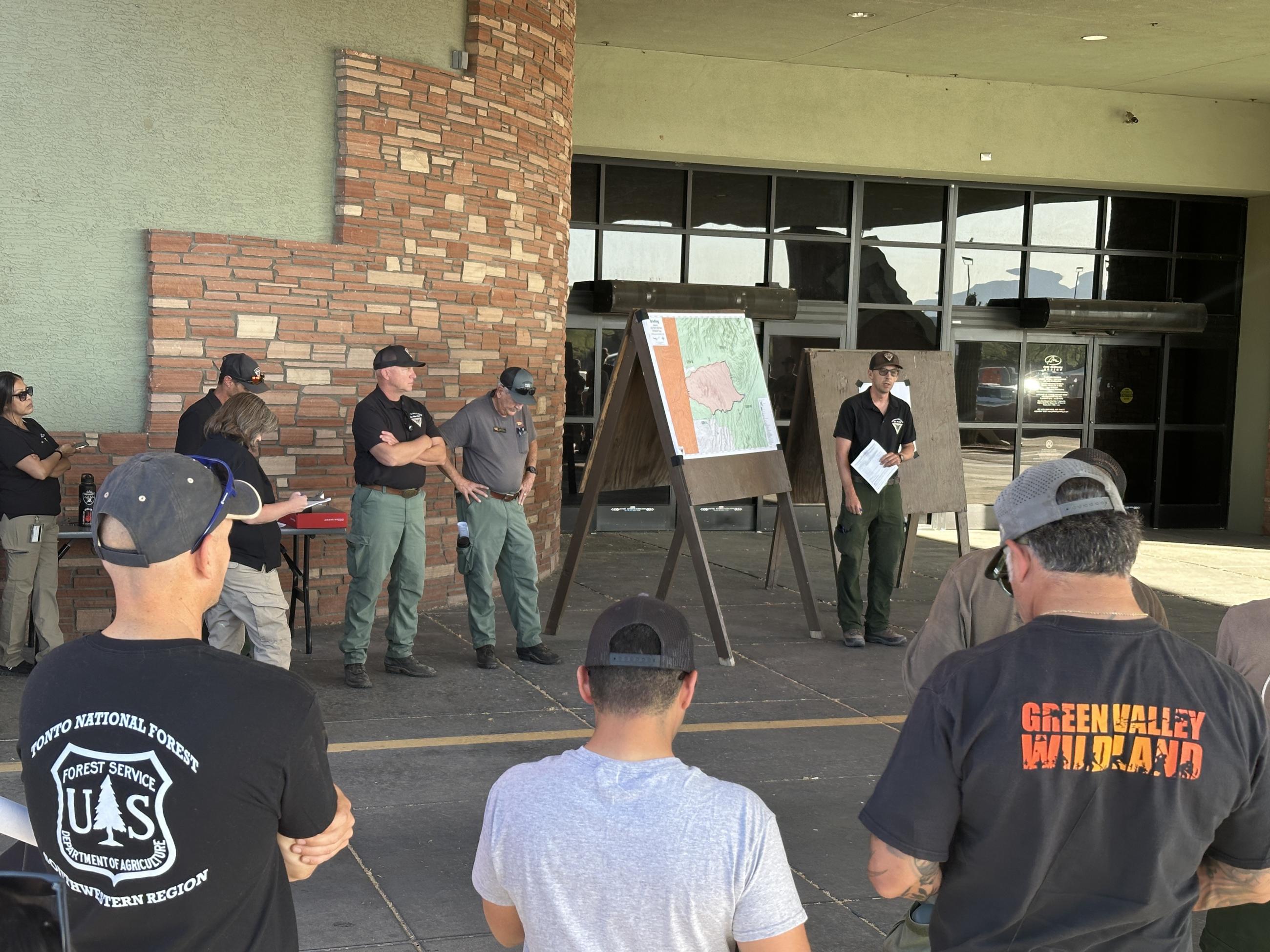 Resources assigned to the Adams Fire listen to the operational plan at morning briefing